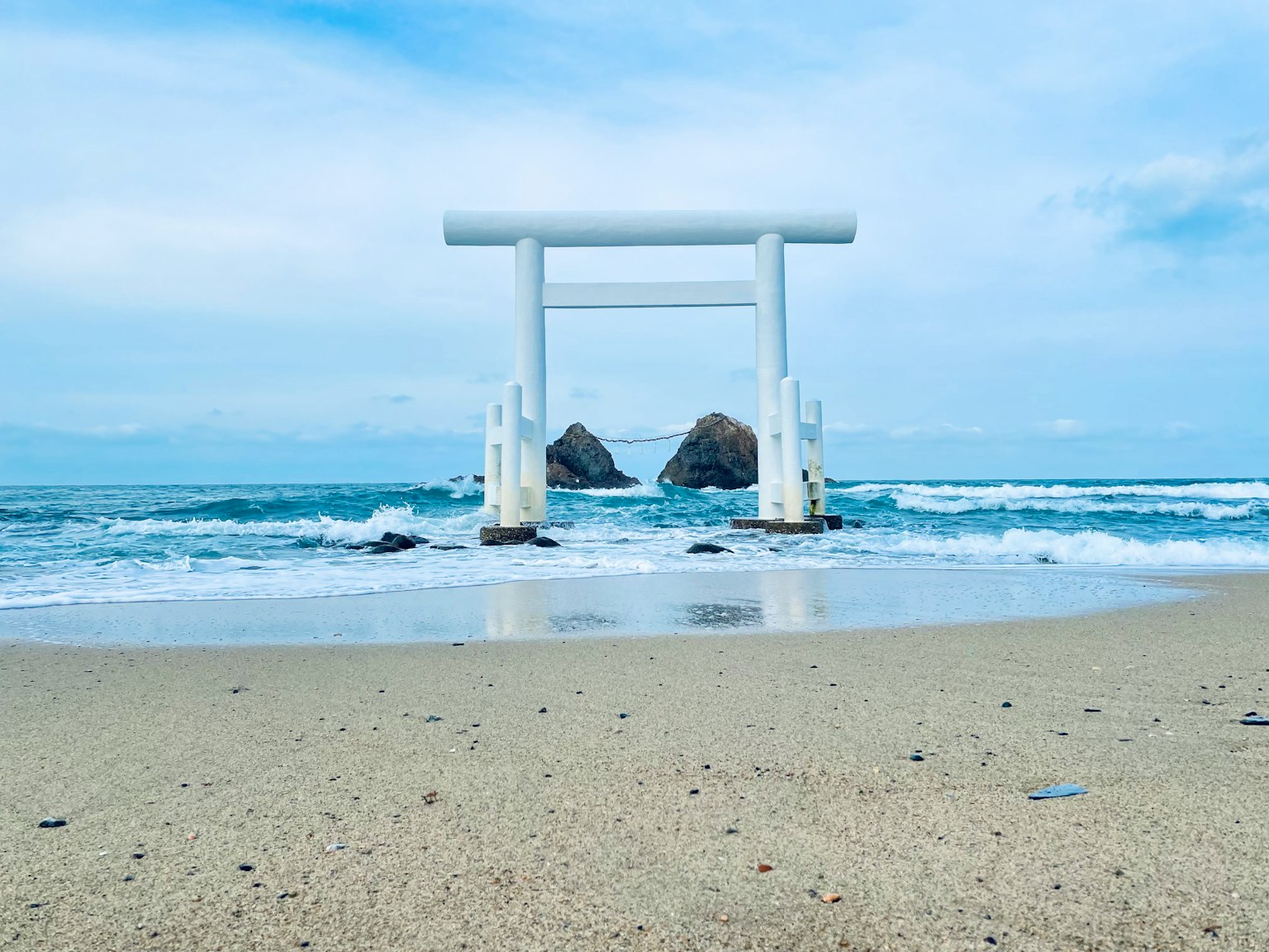 Portique torii blanc et paysage océanique Plage de sable avec torii Ciel bleu et vagues