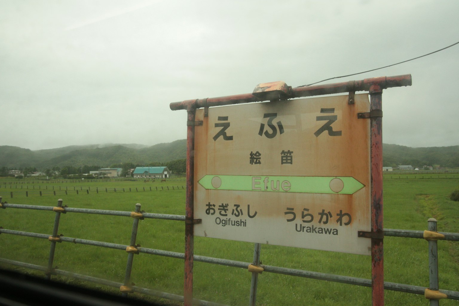 Cartel de la estación Ebue en un paisaje rural