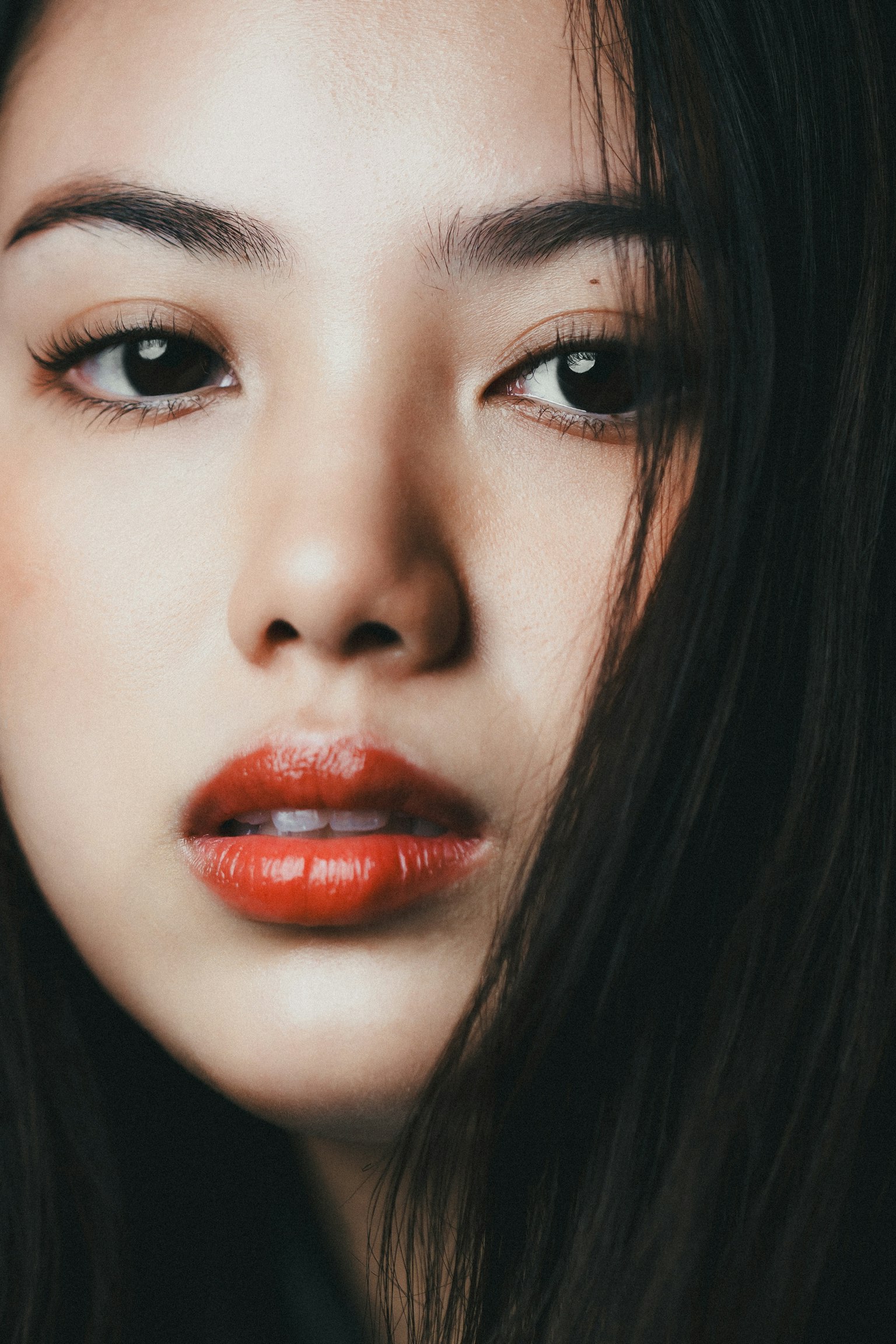 Nahaufnahme eines schönen Frauenangesichts mit natürlichem Make-up und lebhaften roten Lippen