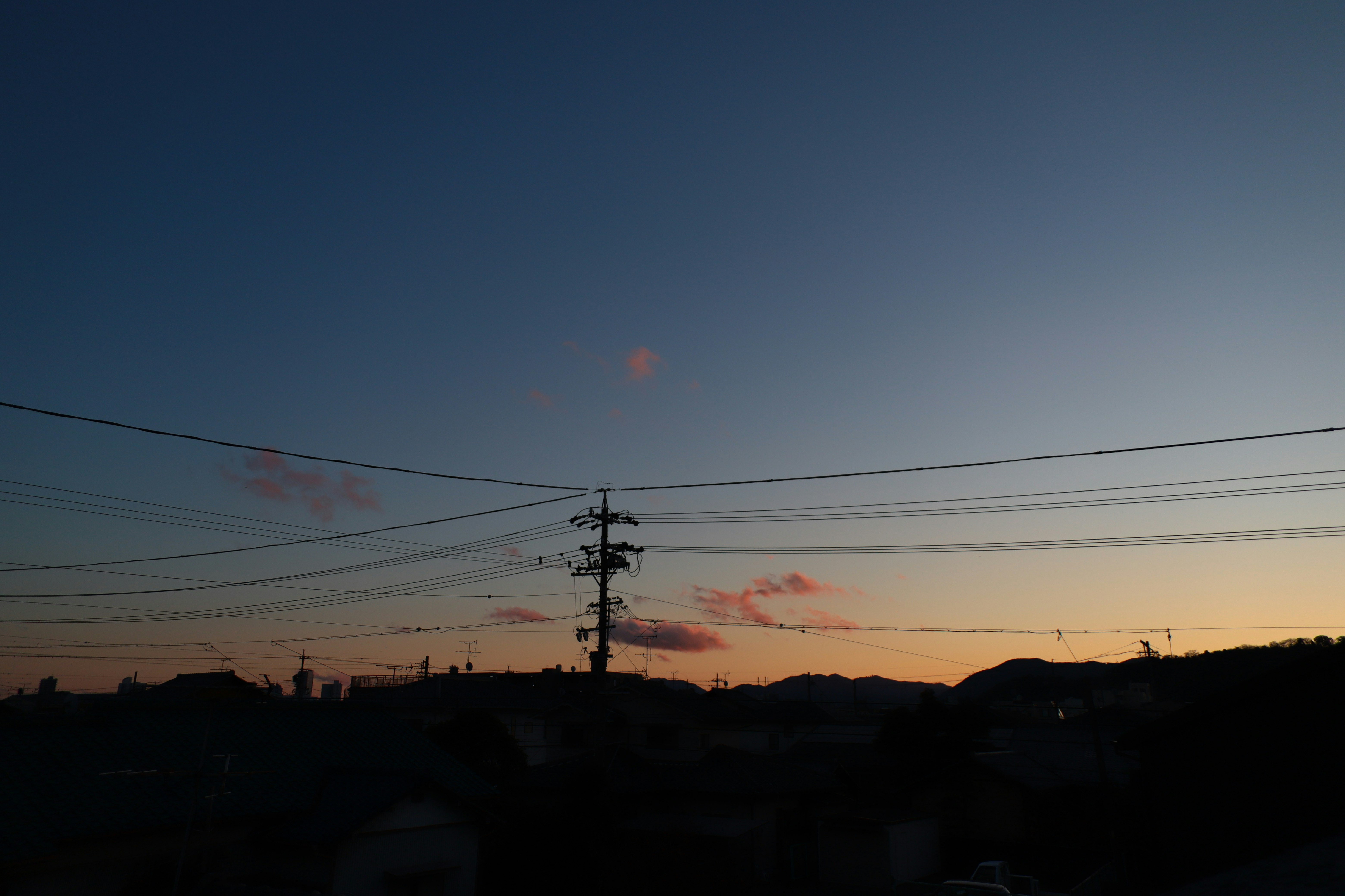 夕阳天空下的城镇天际线与电线剪影