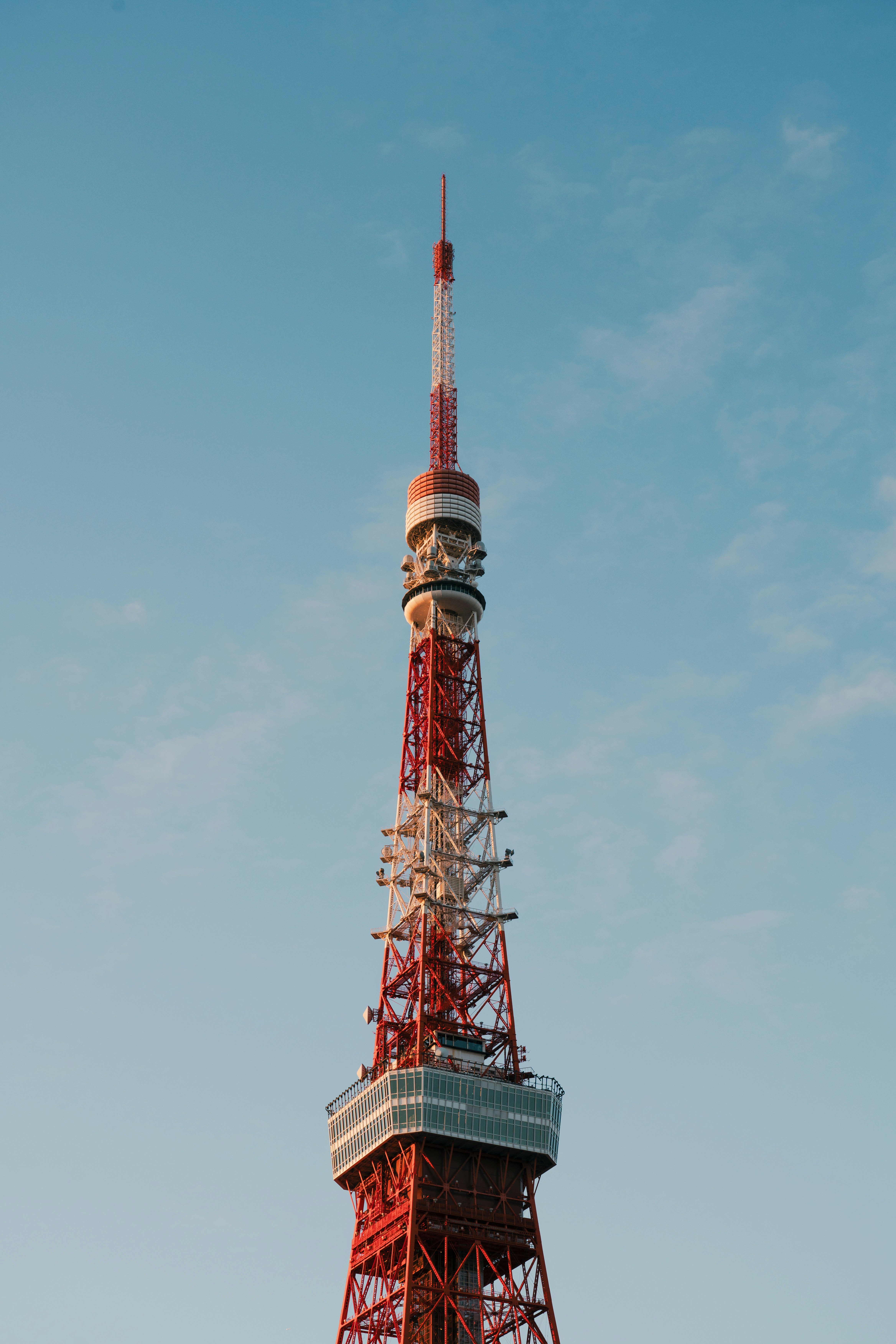 青空にそびえる赤い電波塔の全景