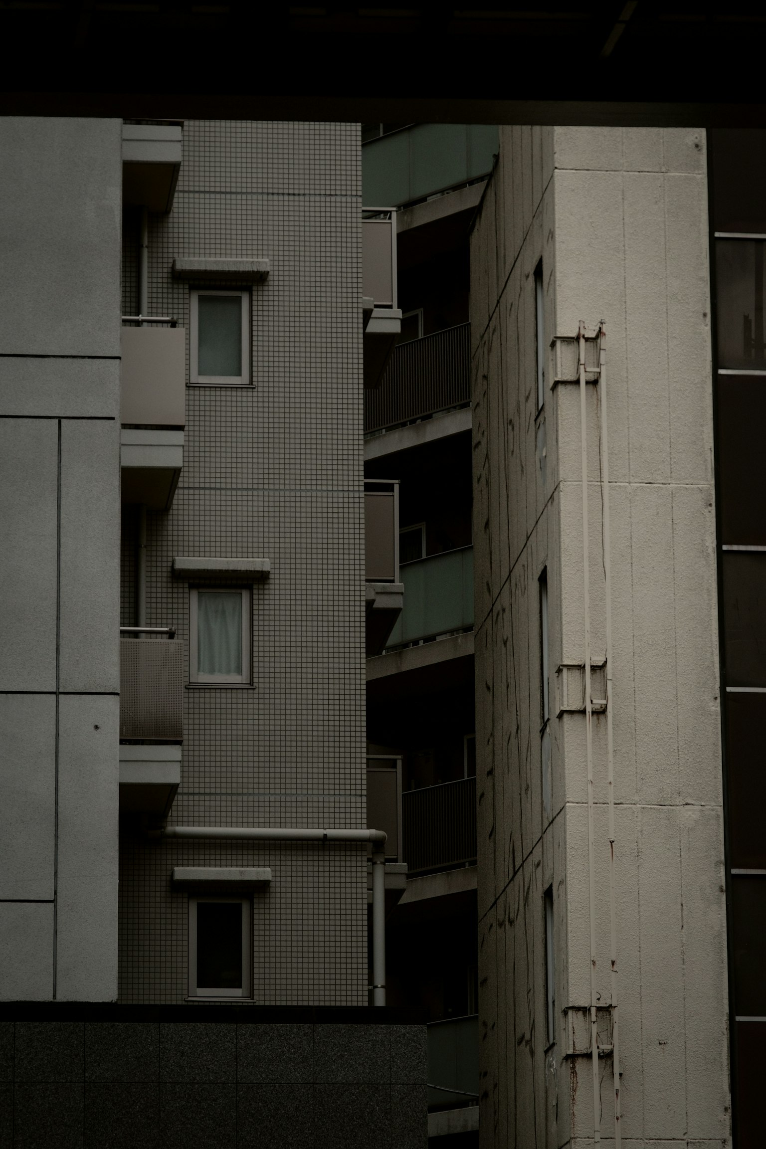 Urban landscape featuring dark-colored buildings with balconies