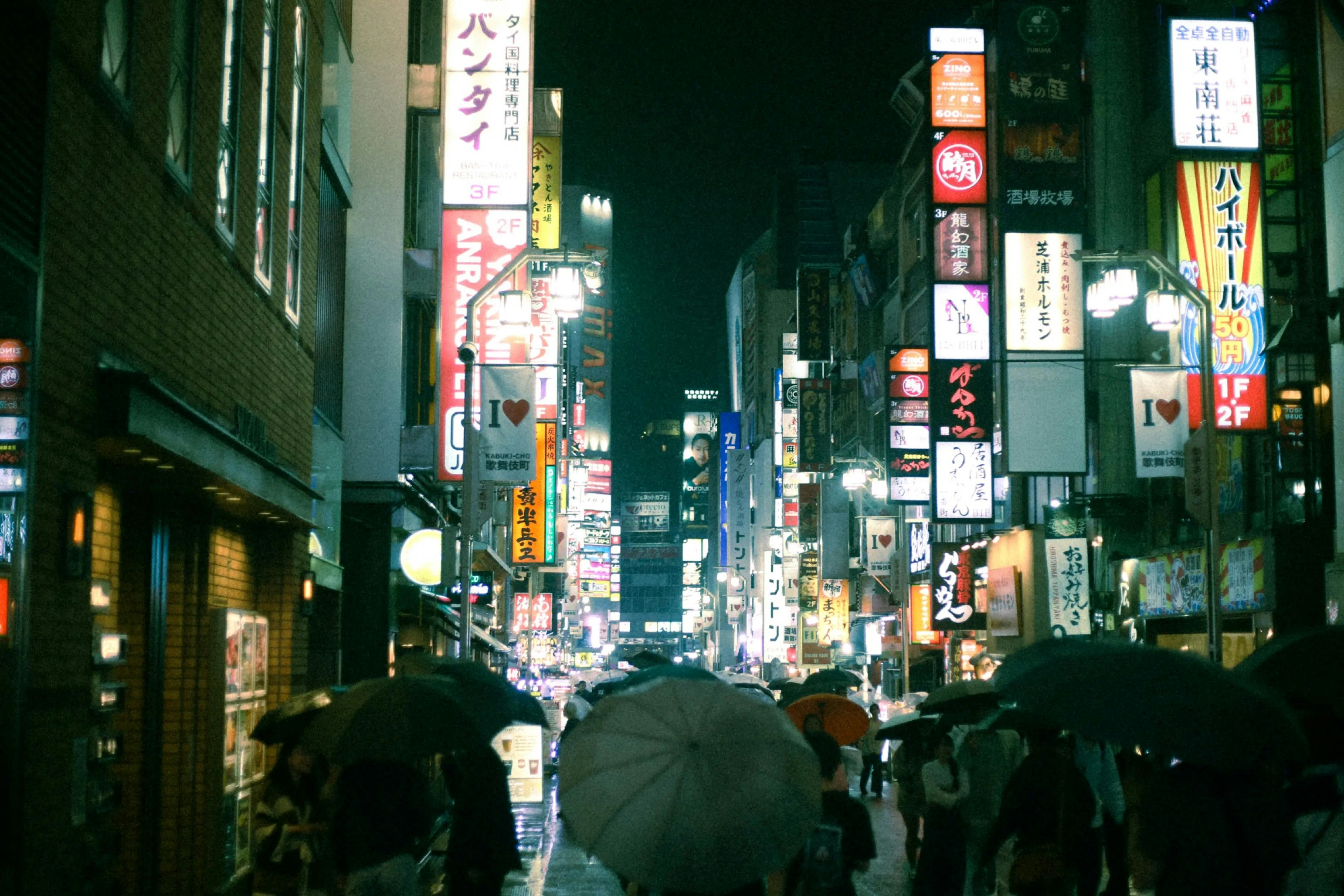 夜のネオンが並ぶ狭い路地の商店街