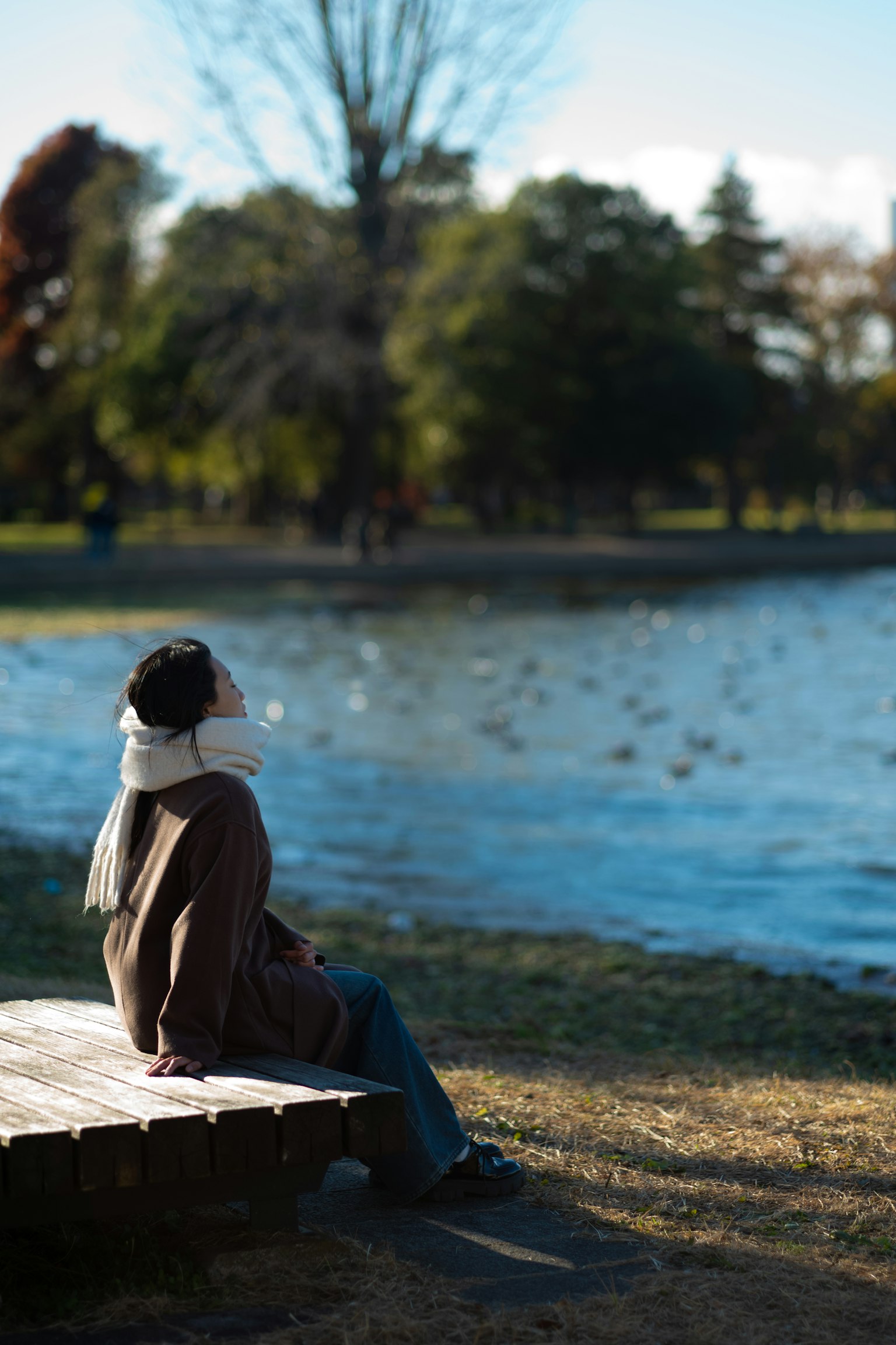 Persona seduta vicino a uno stagno che gode di un paesaggio sereno