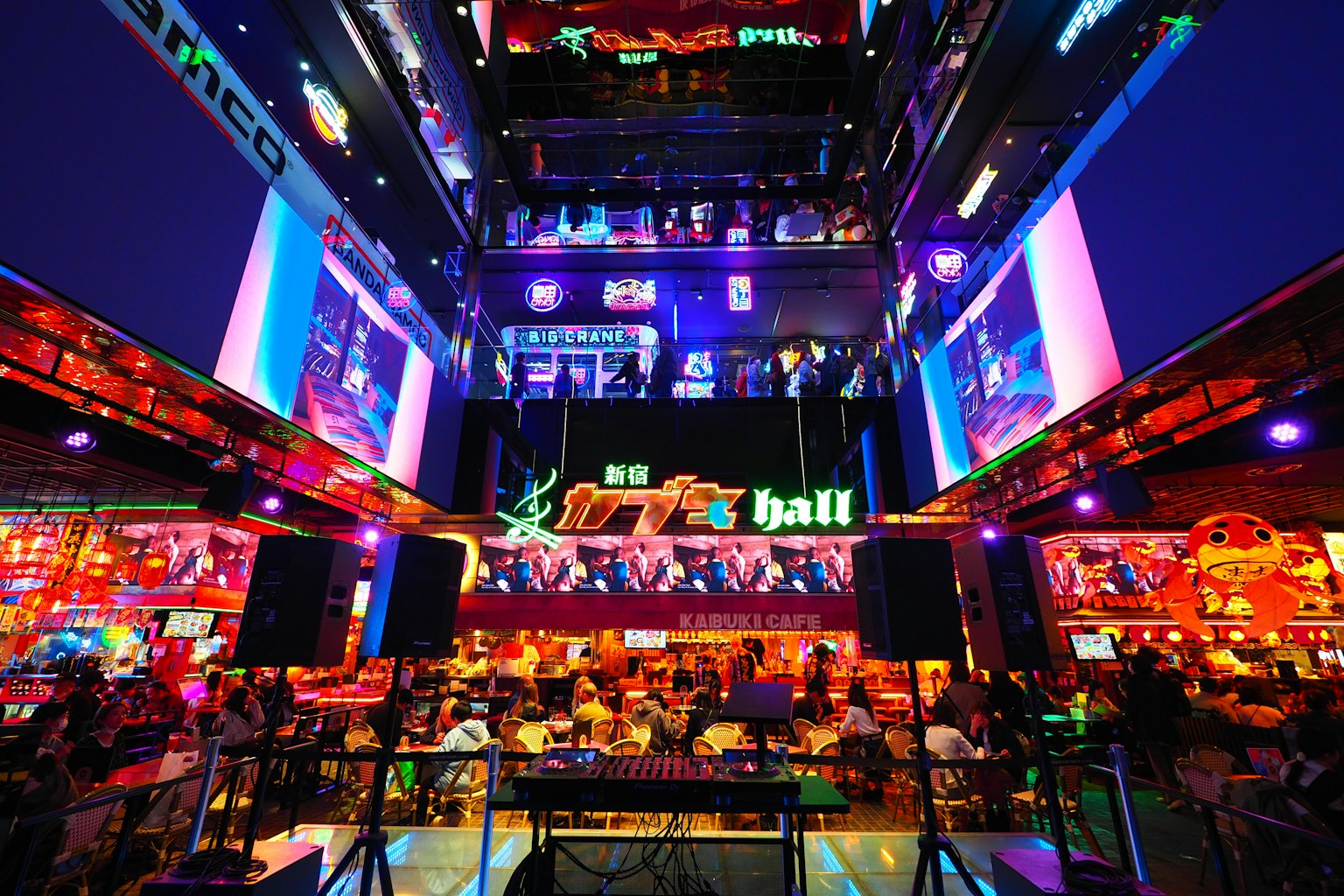 Interior bar yang hidup dengan lampu neon cerah dan banyak pengunjung yang menikmati waktu mereka