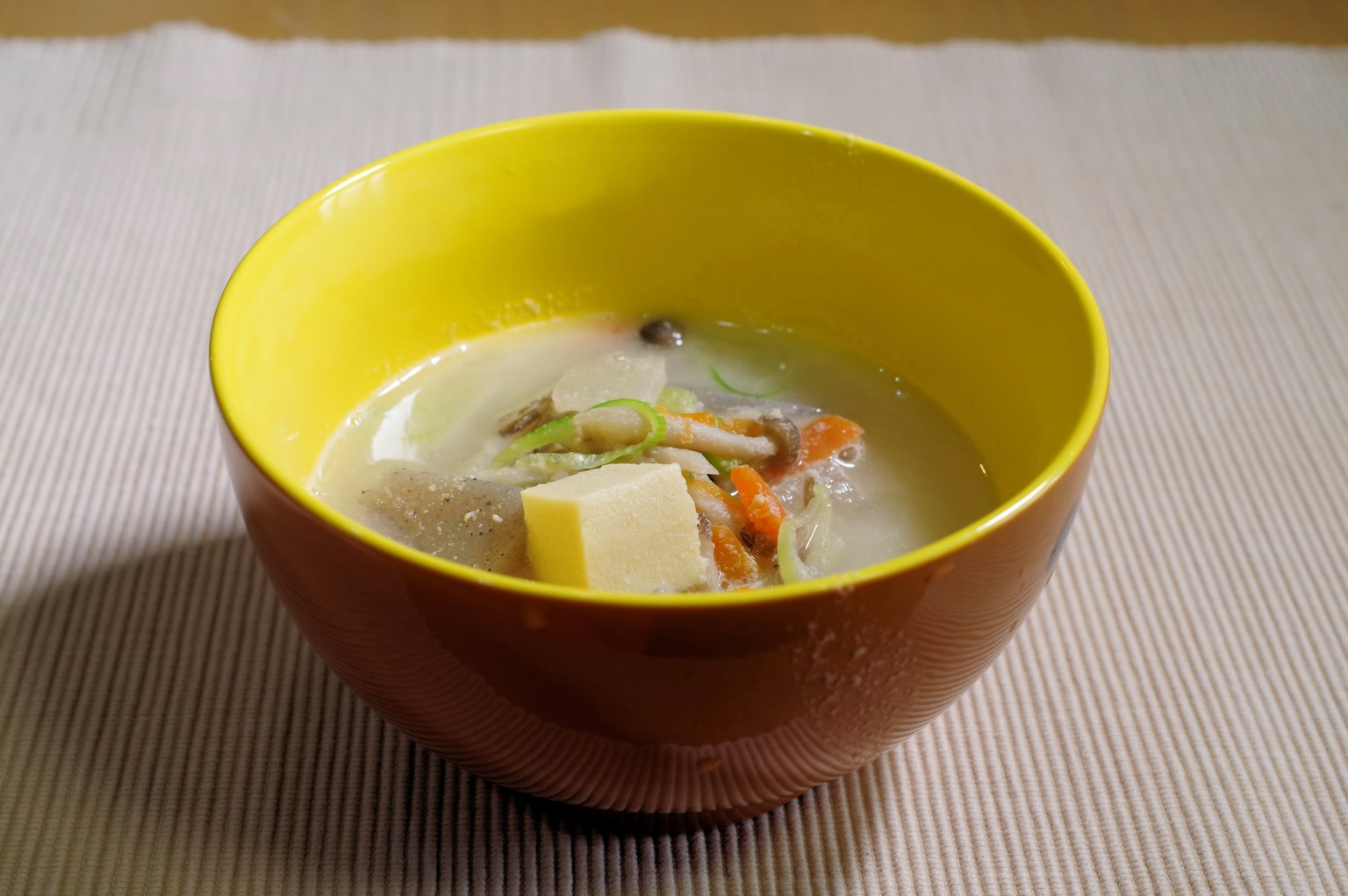 Warme Suppe in einer gelben und braunen Schüssel