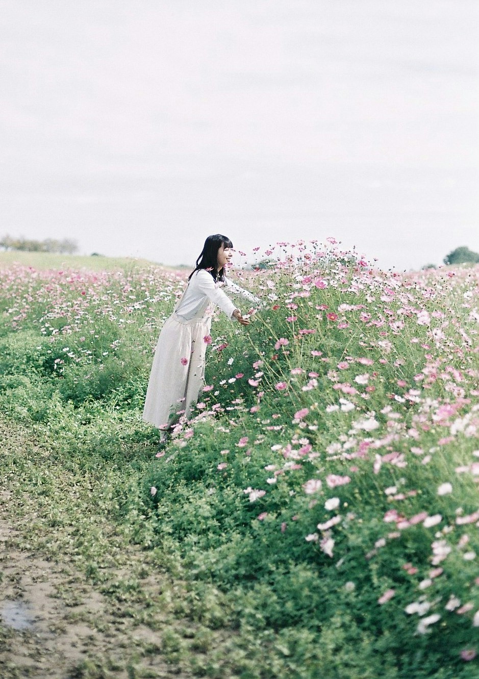mujer con vestido ondeante en un campo de flores