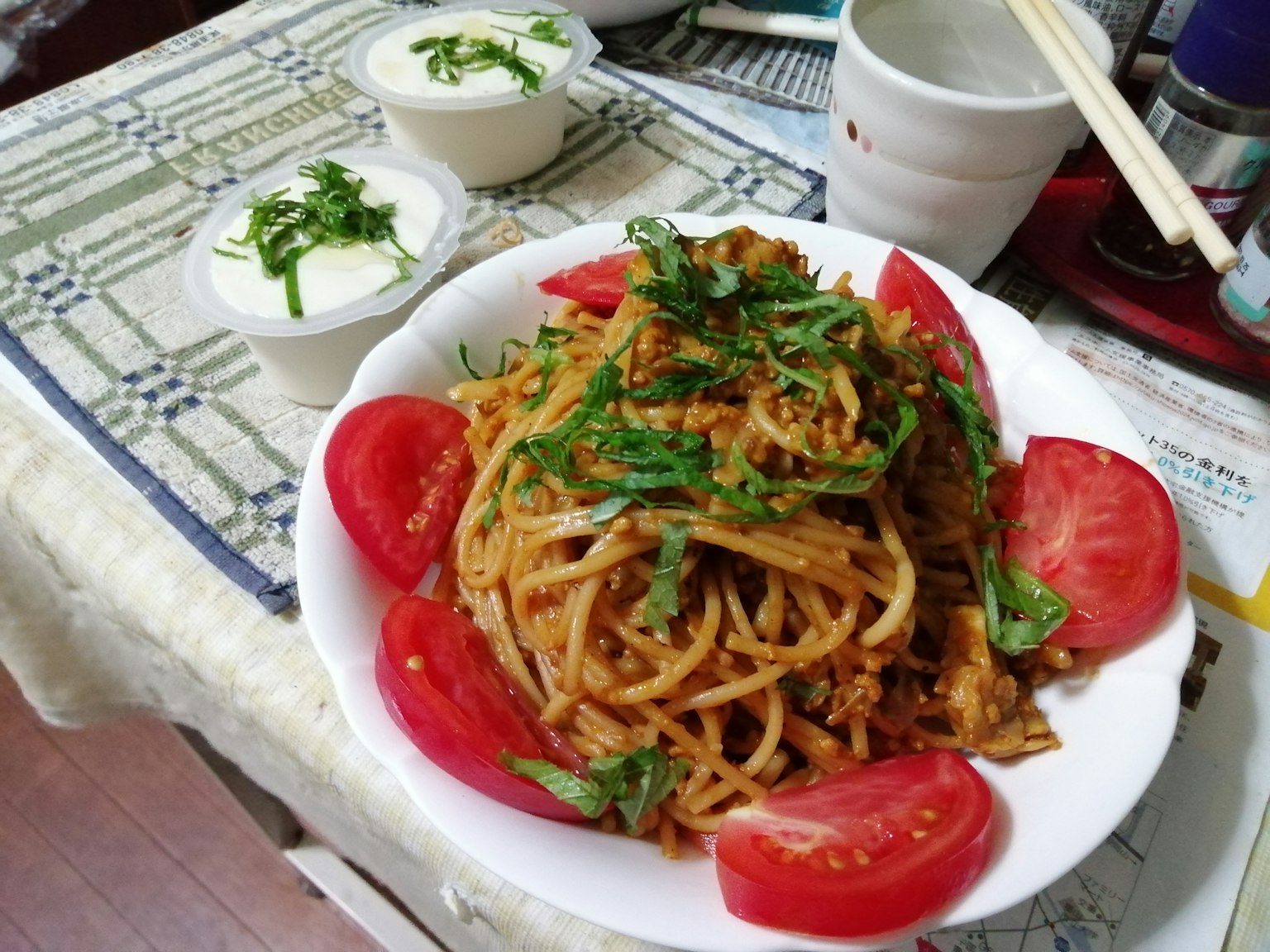 A plate of pasta topped with tomatoes and herbs
