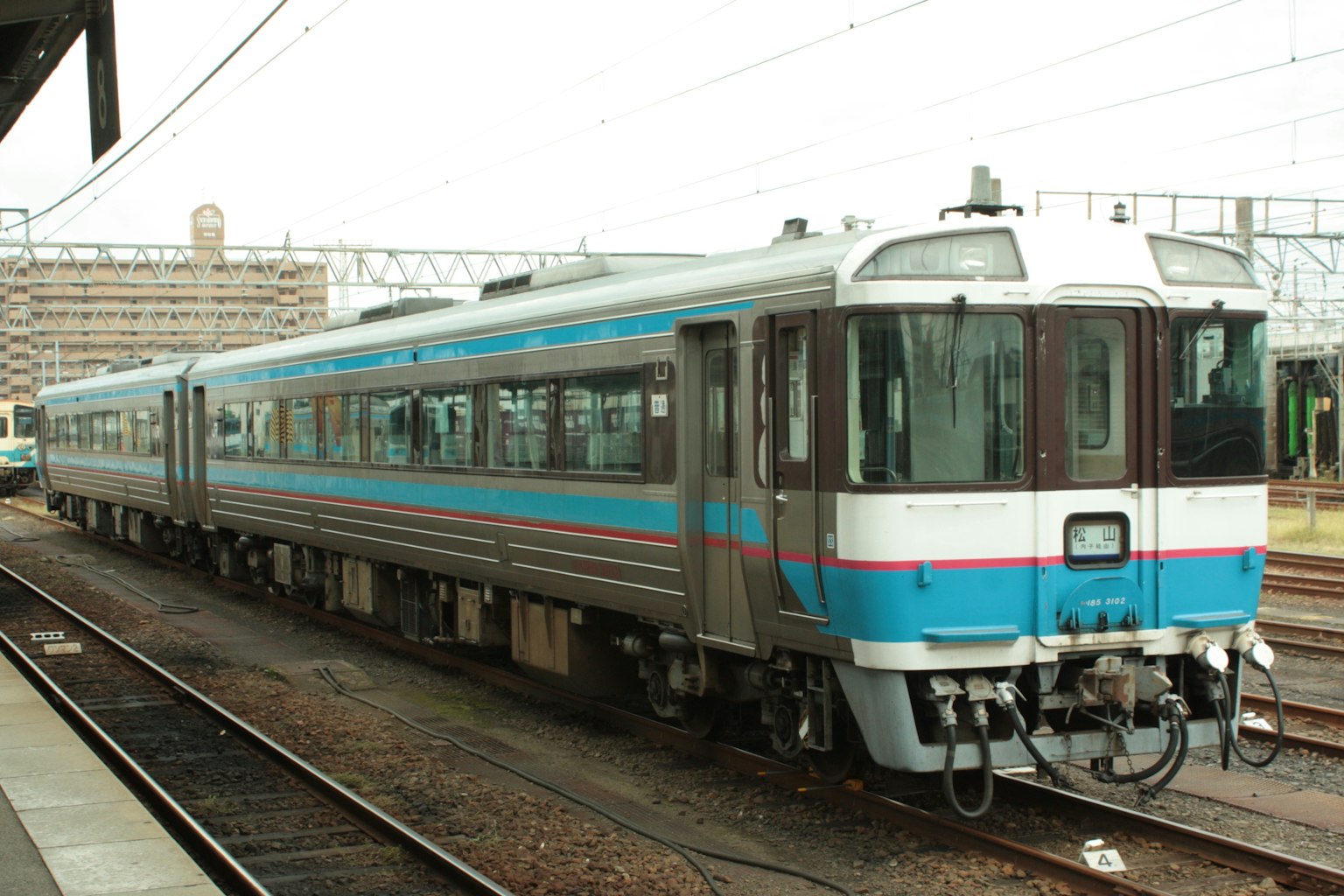 รถไฟที่มีลายสีฟ้าและสีขาวที่โดดเด่นจอดอยู่ที่สถานี