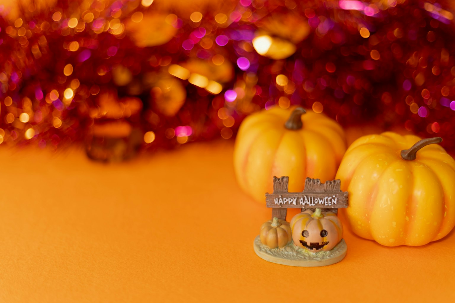 Piccole zucche con decorazione di Halloween su sfondo arancione