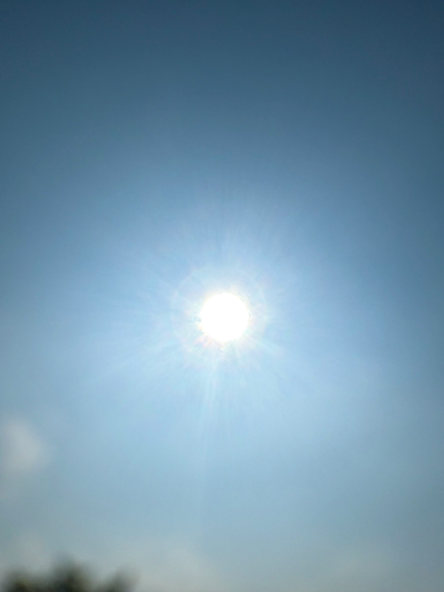 Blurred image of the sun shining in a clear blue sky