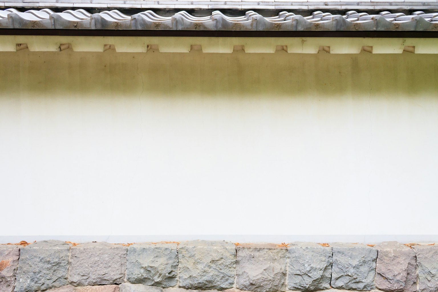 Einfaches Äußeres eines Gebäudes mit einer traditionellen japanischen Wand und einem Steinfundament