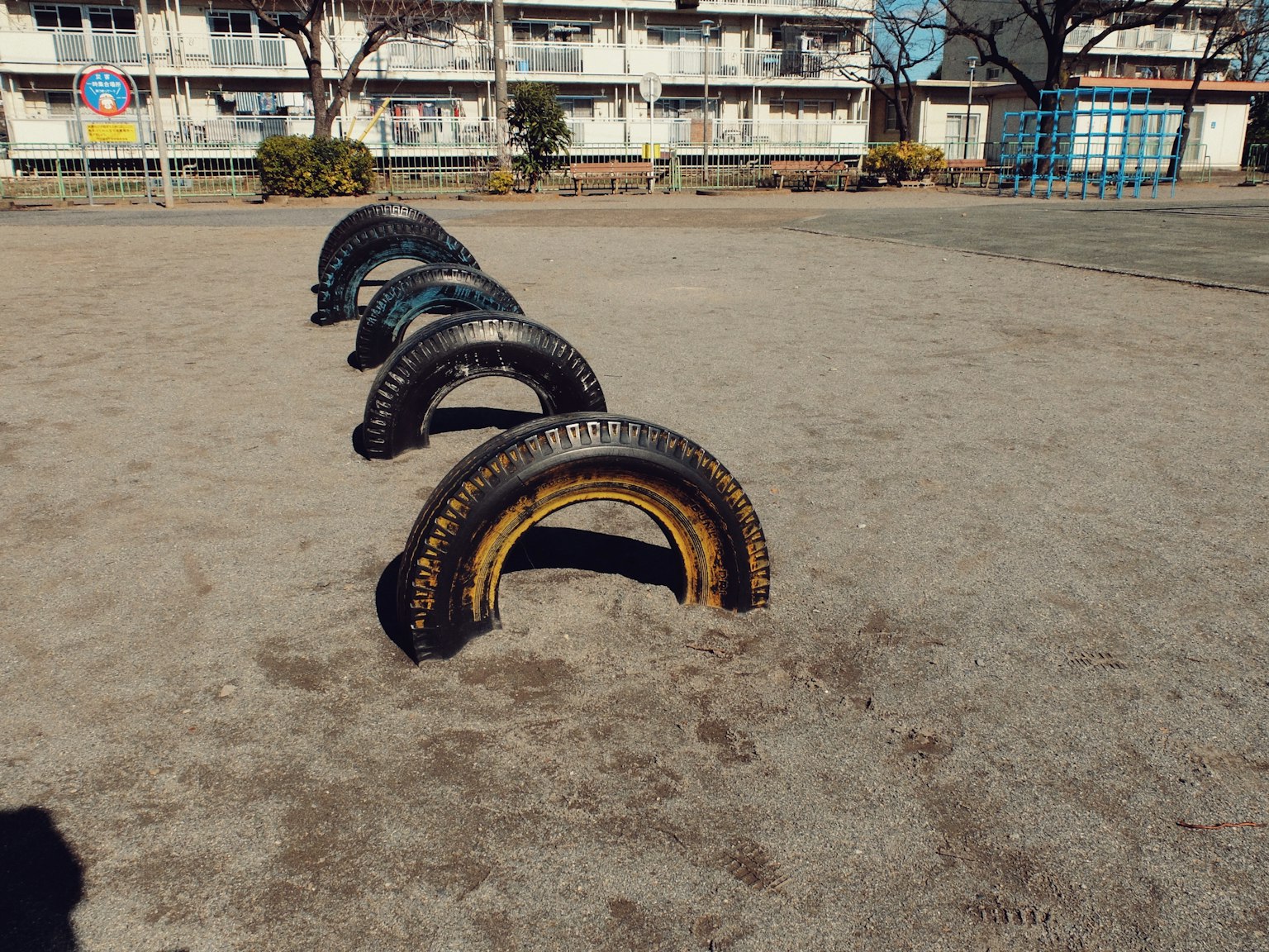 Colorful tire playground equipment in a sandy park area