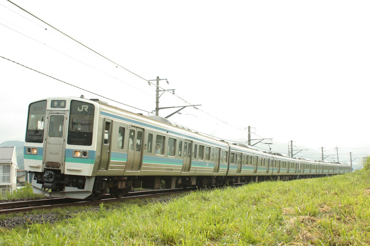 รถไฟยาวที่วิ่งข้างสนามหญ้าสีเขียว