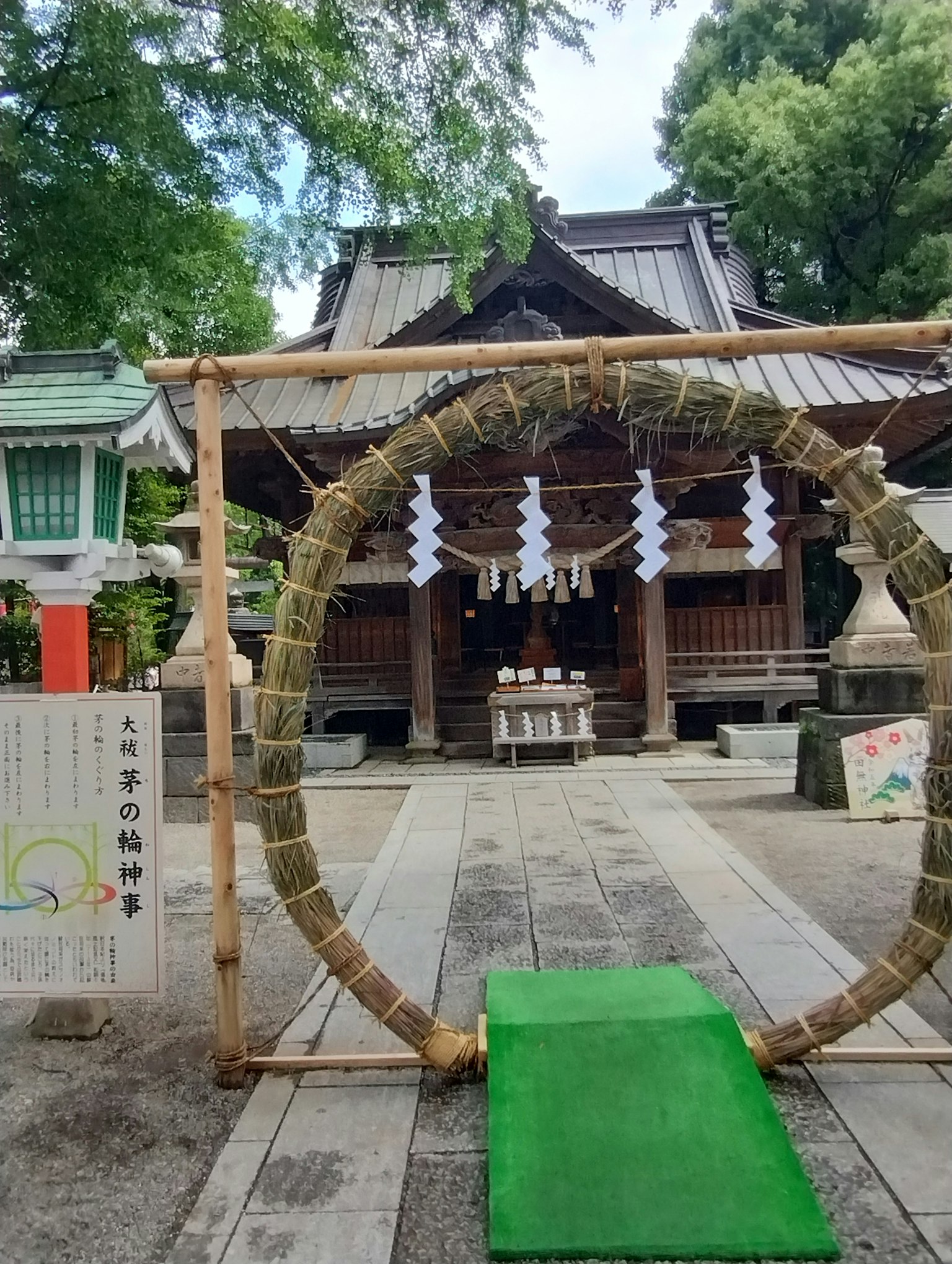 A large straw ring and green path in front of a shrine