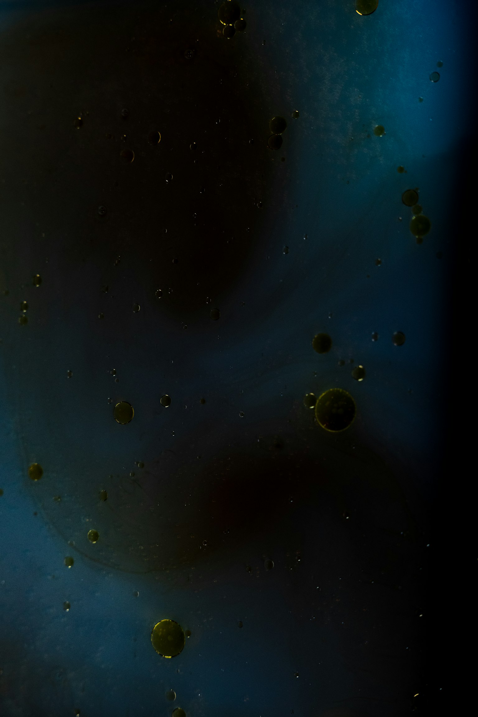 Imagen abstracta con pequeñas esferas flotando en un fondo azul y negro