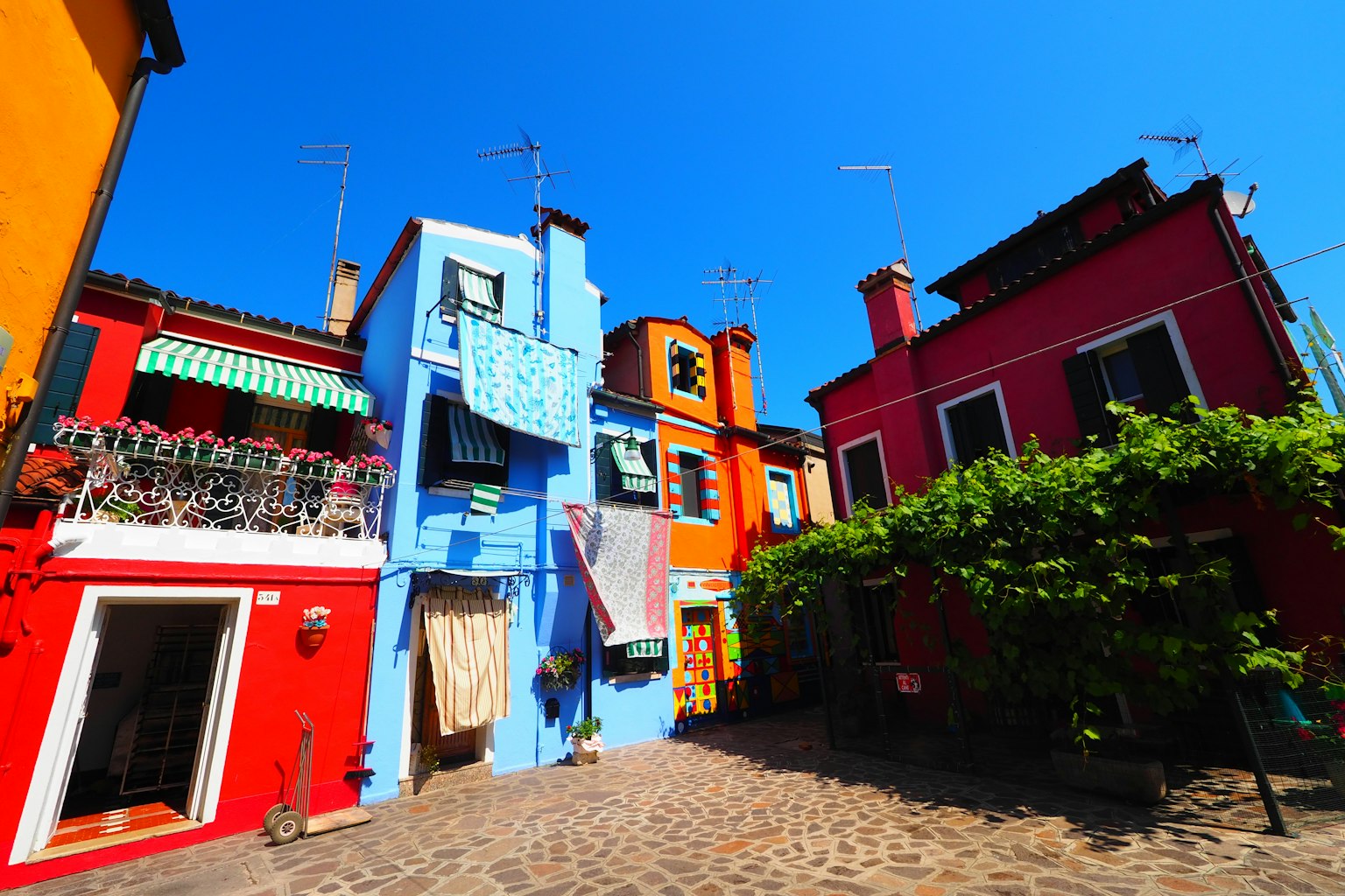 Bâtiments colorés alignés dans une rue étroite sous un ciel bleu