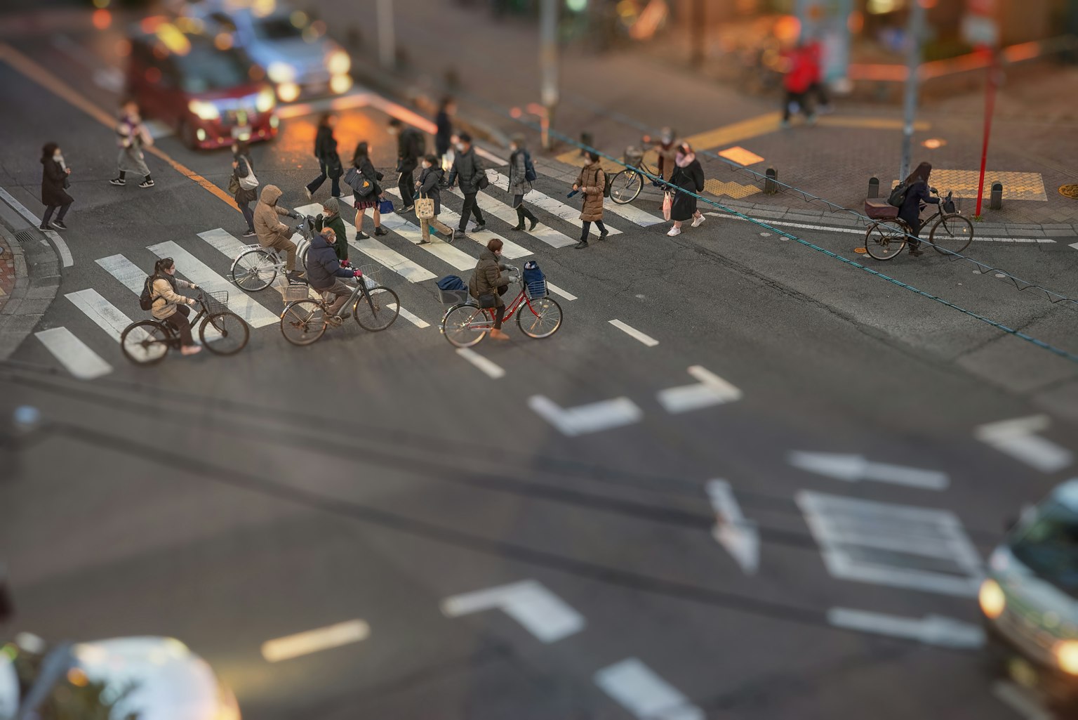 Ciclisti e pedoni che attraversano a un incrocio affollato