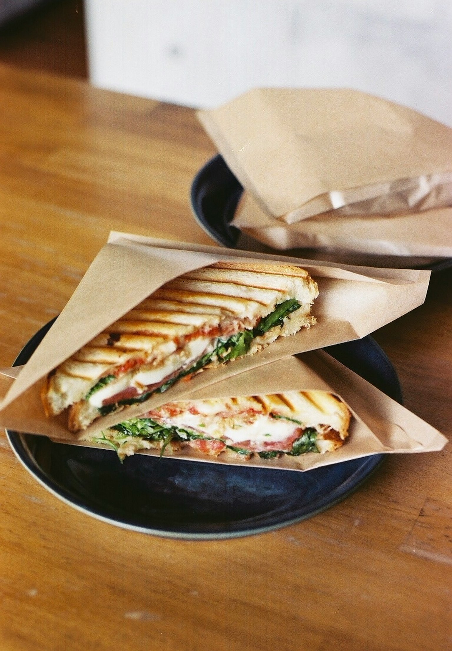 Panino grigliato servito su un piatto con lattuga e pomodoro visibili