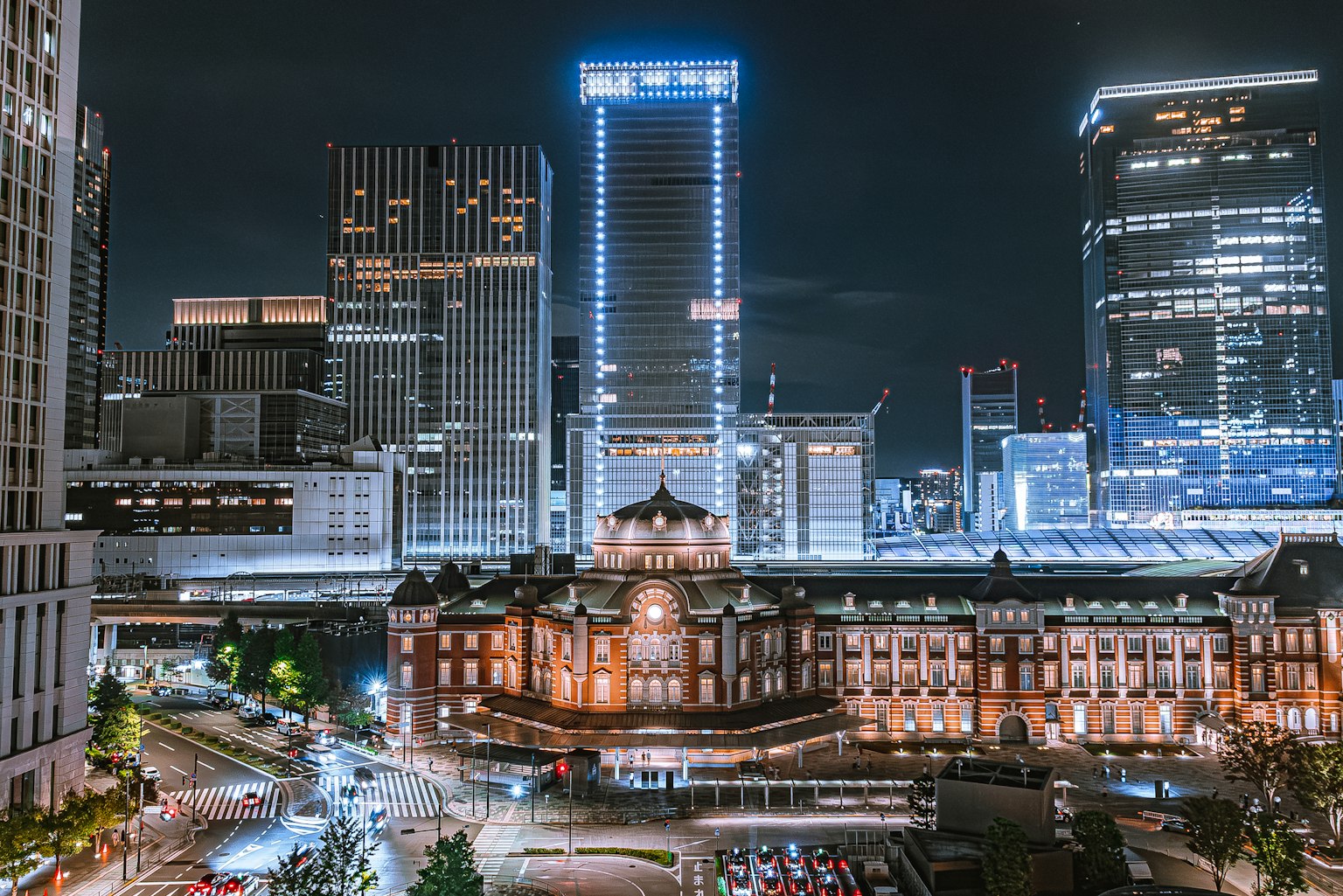 Vista nocturna de la estación de Tokio y rascacielos modernos