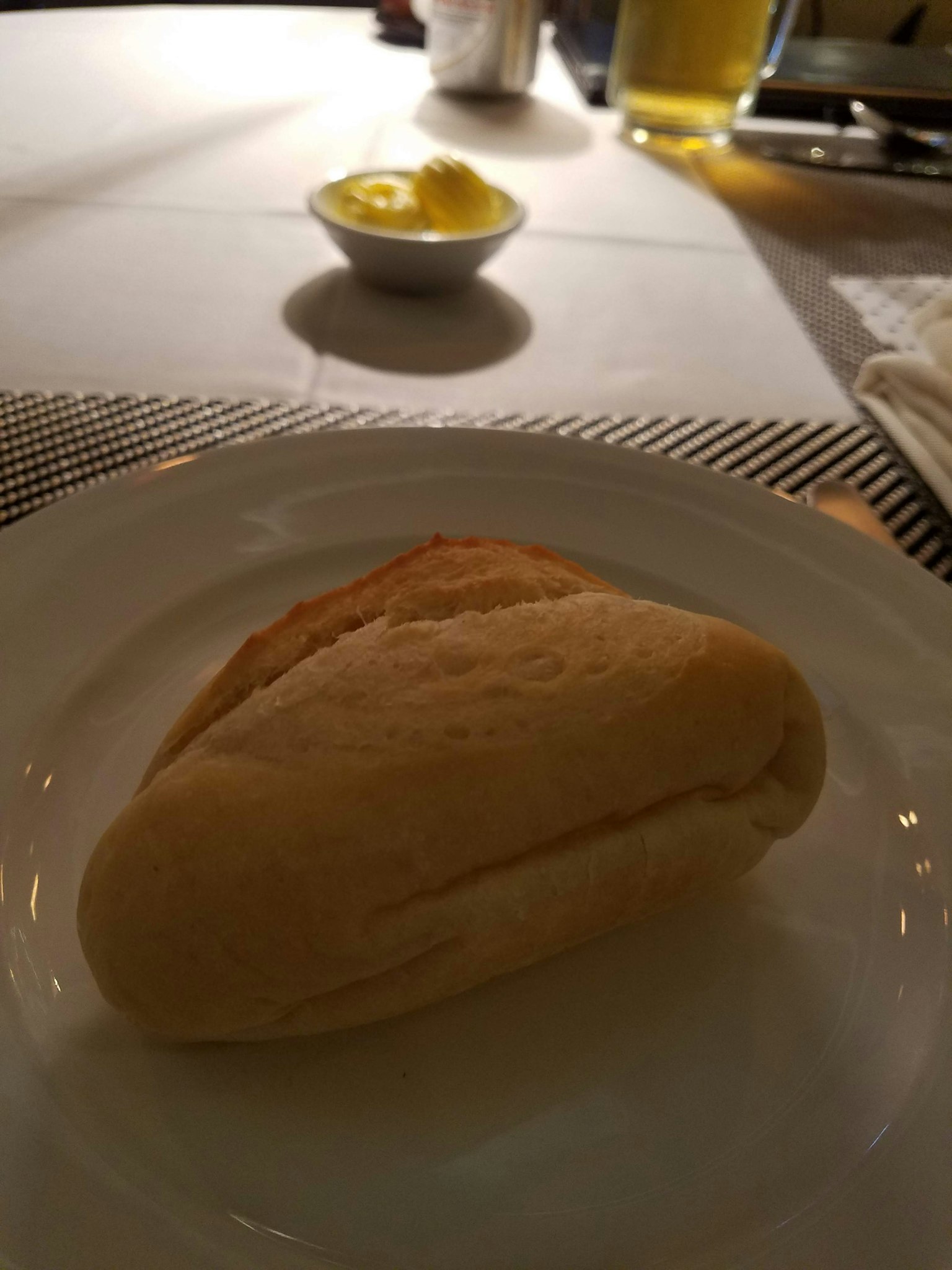白色盤子上的軟麵包和背景中的黃油