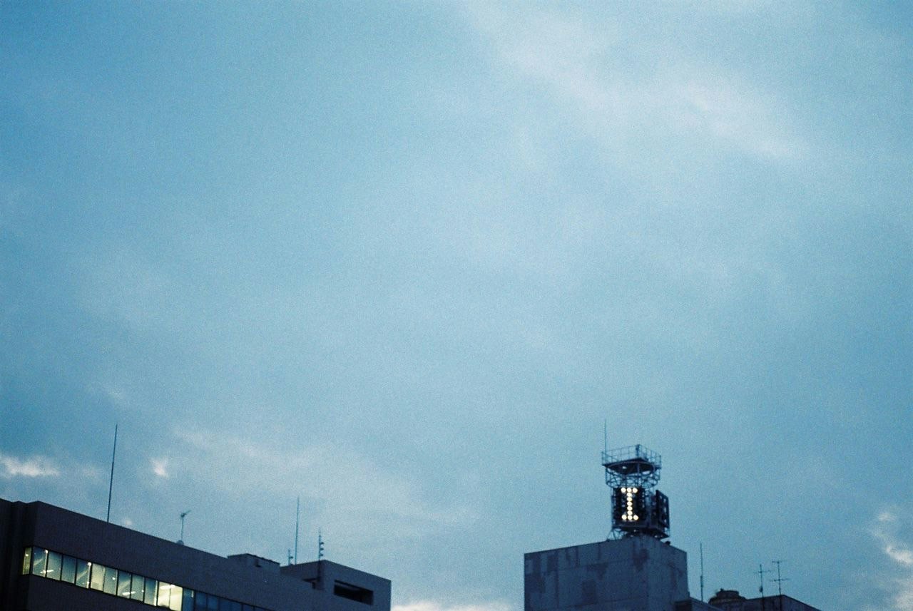 Kommunikationsantennen und ein Dachturm vor blauem Himmel