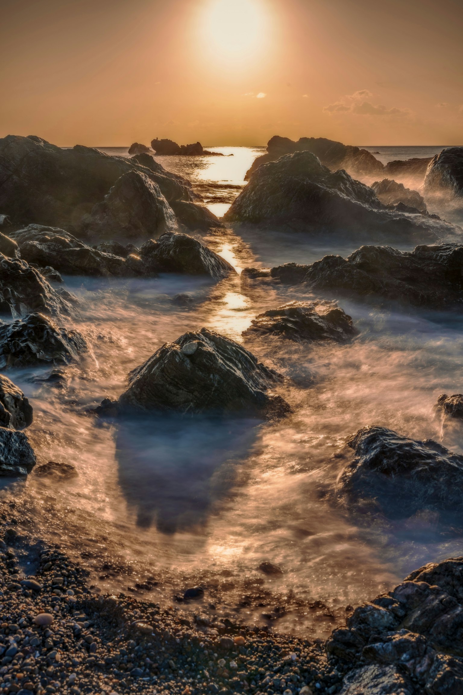 Malersiche Aussicht auf die felsige Küste mit Wellen und Sonnenuntergang
