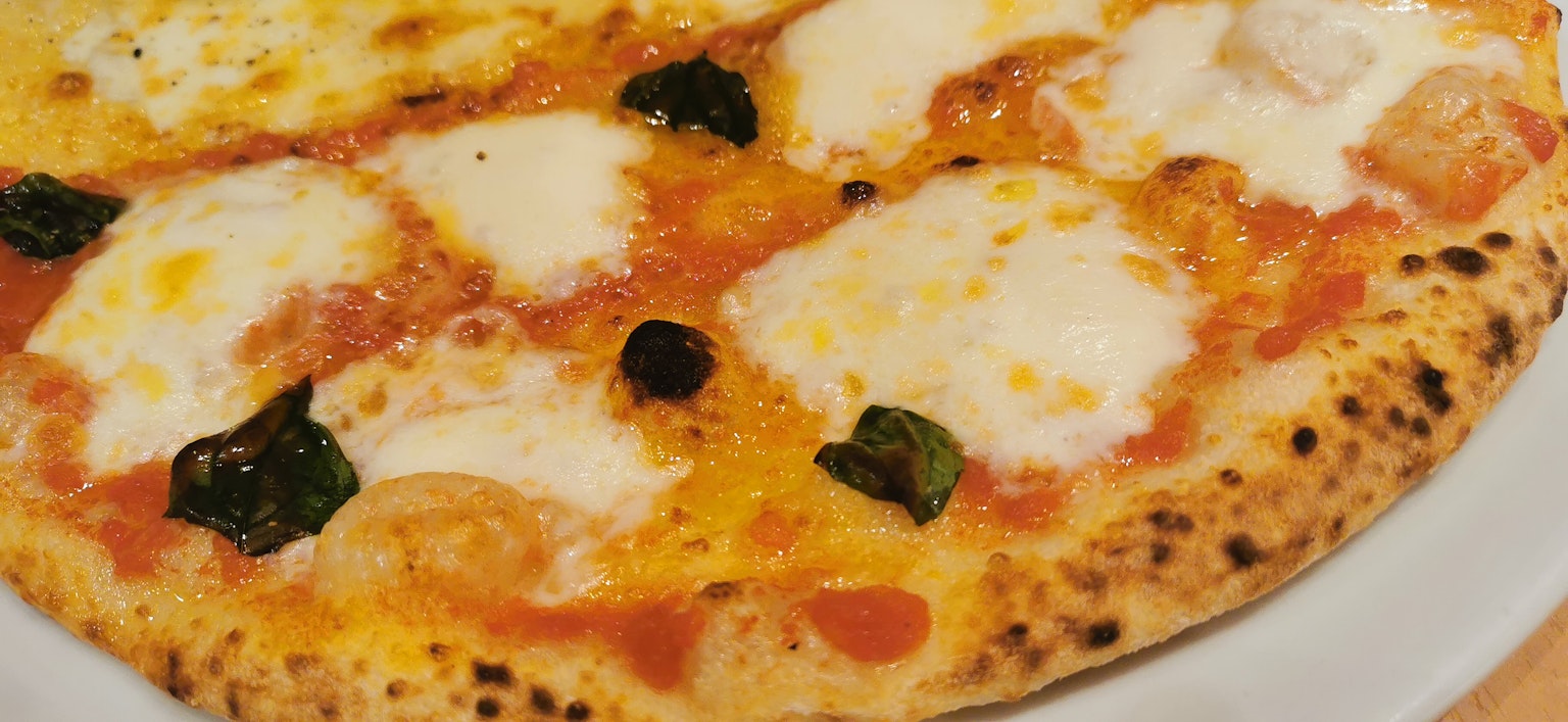 Pizza Margherita appena sfornata servita su un piatto