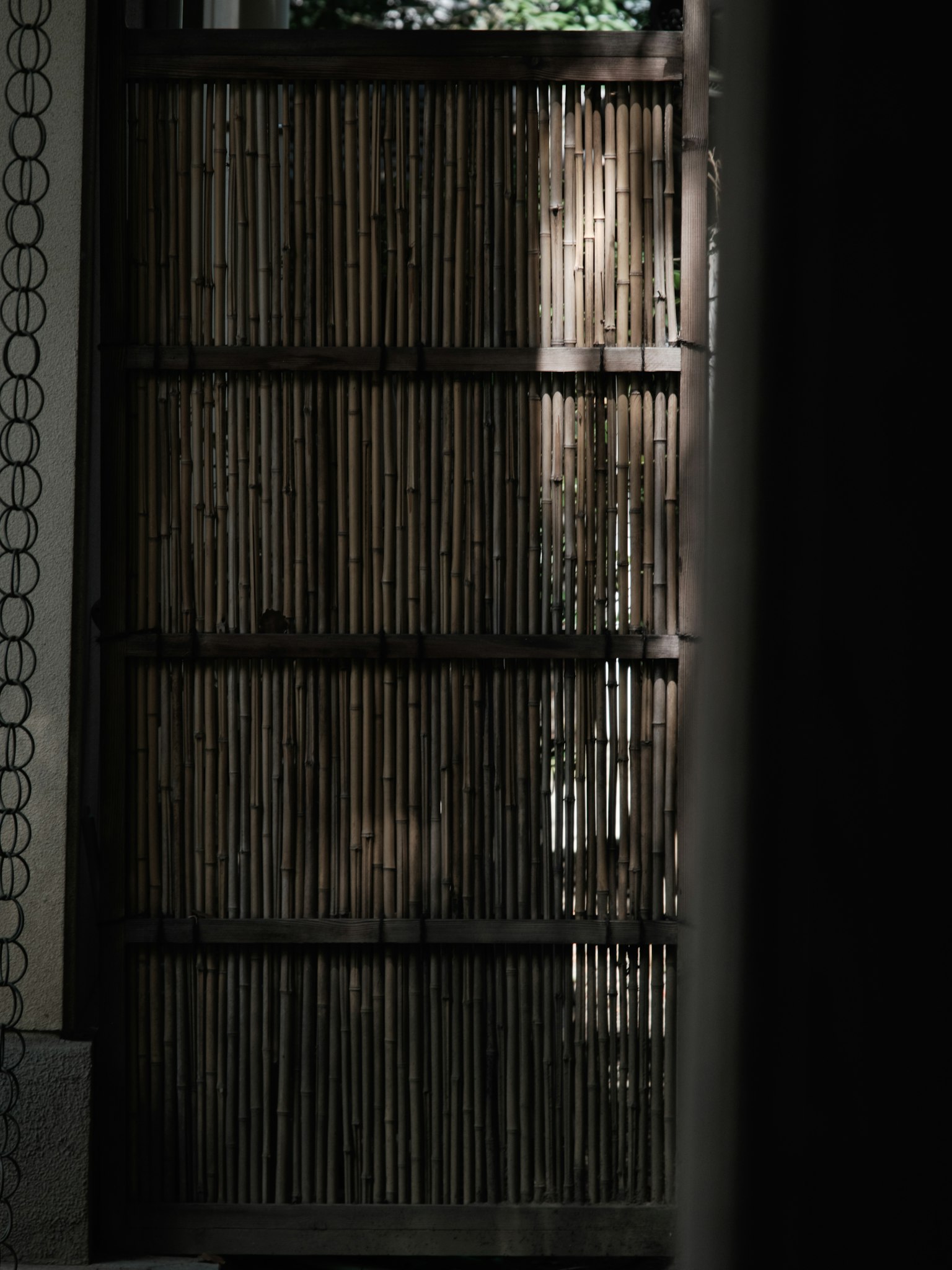 A bamboo gate with intersecting shadows and light