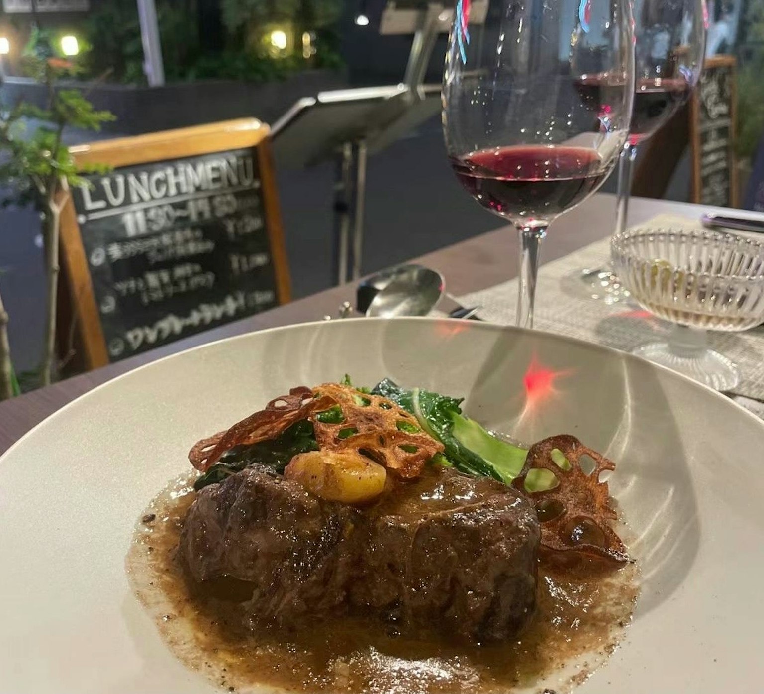 Un plat de viande savoureux avec un verre de vin rouge sur une table à manger