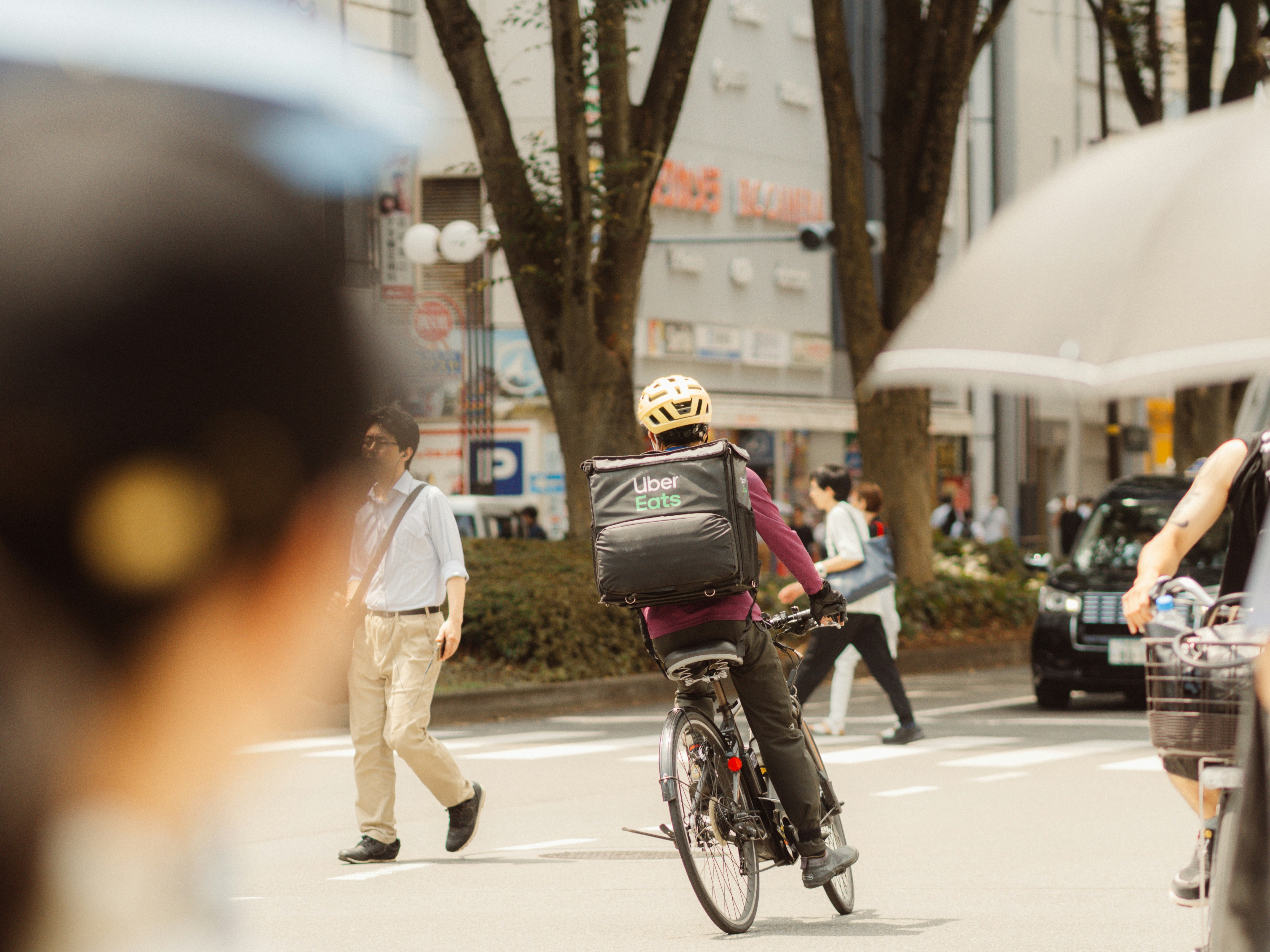 路地の自転車配達員と歩行者のある街角