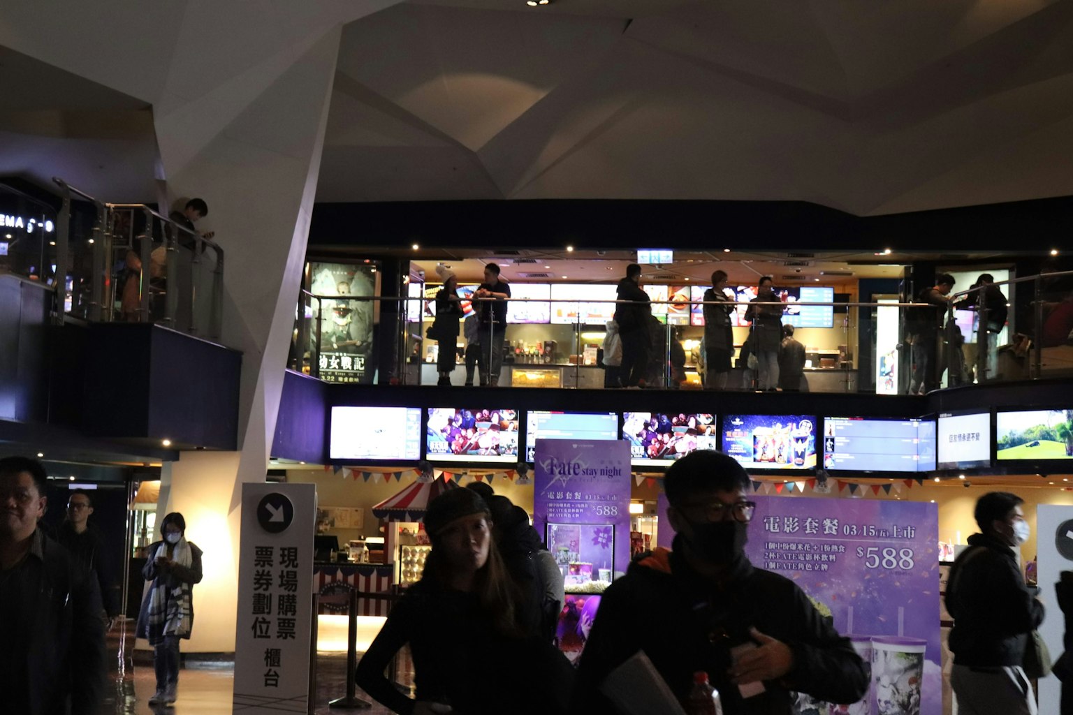 Interno di uno spazio commerciale moderno con persone sul balcone superiore e al piano inferiore