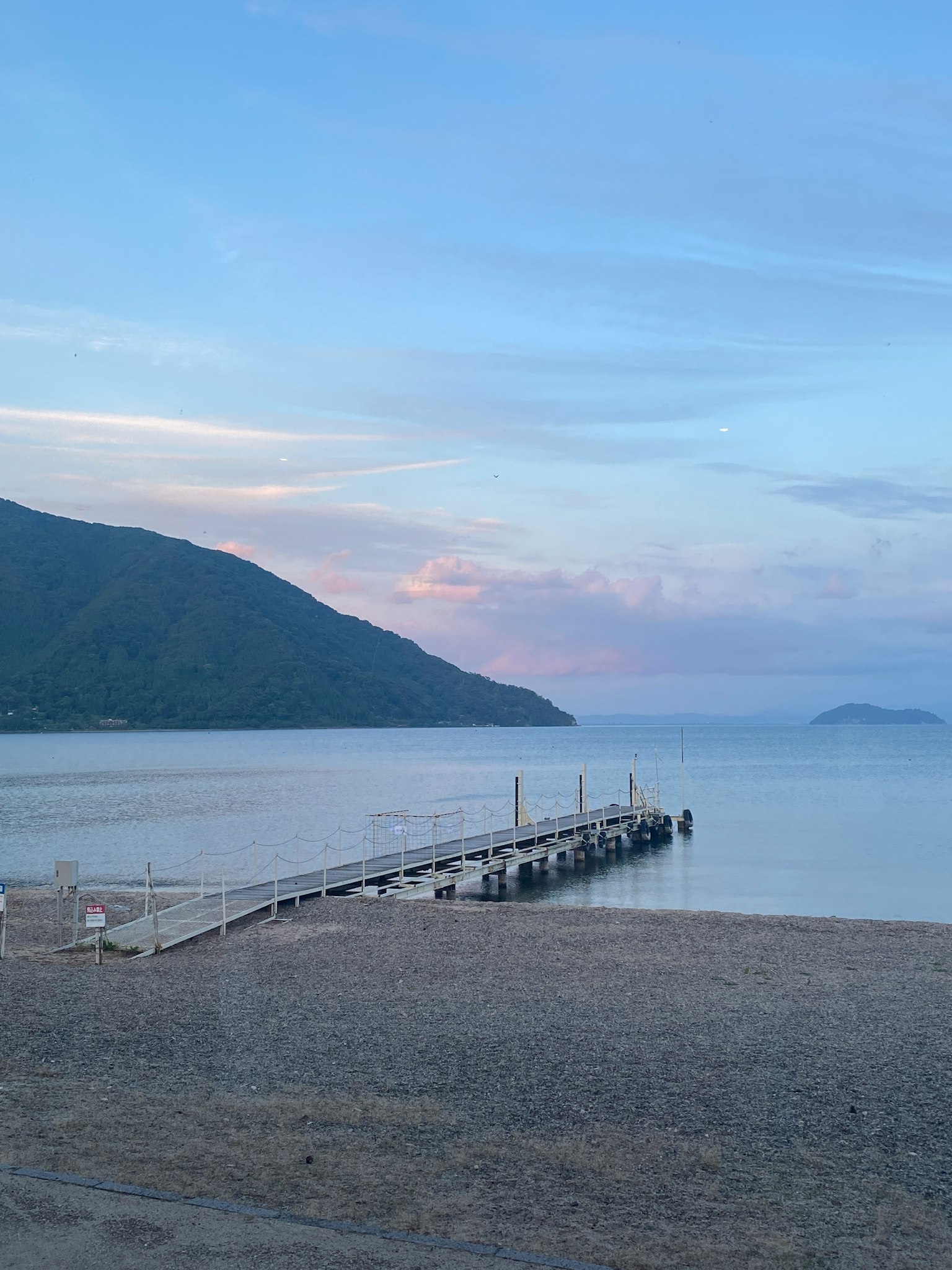 寧靜的海景，碼頭和山脈在柔和的天空下