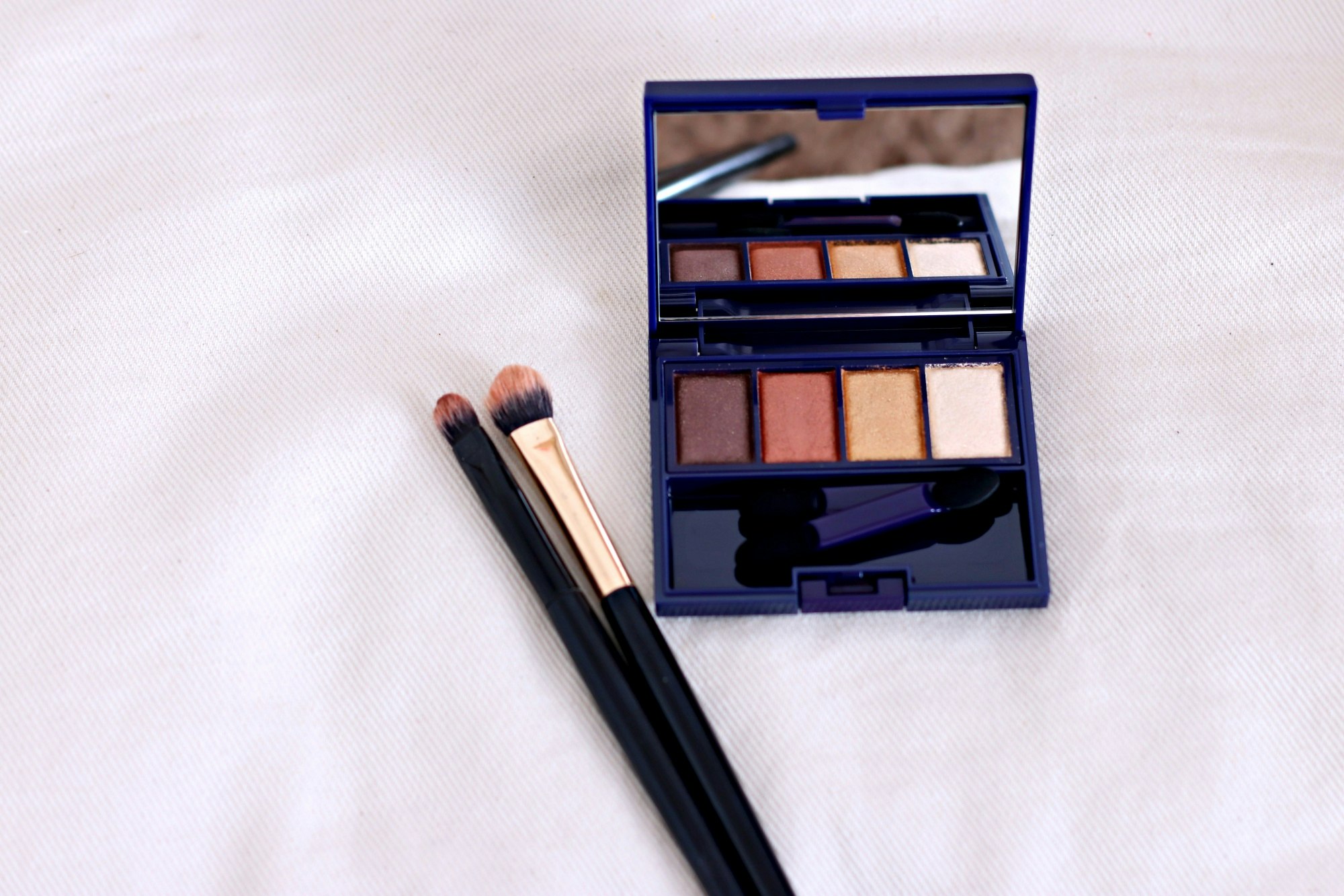 makeup palette and makeup brush on a light background