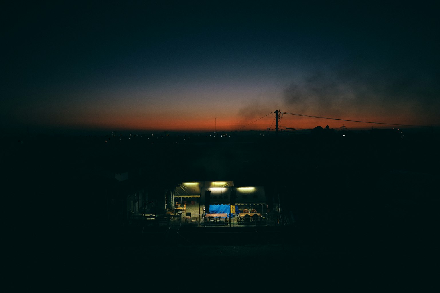 Extérieur d'une usine au crépuscule Lumières vives illuminent l'intérieur