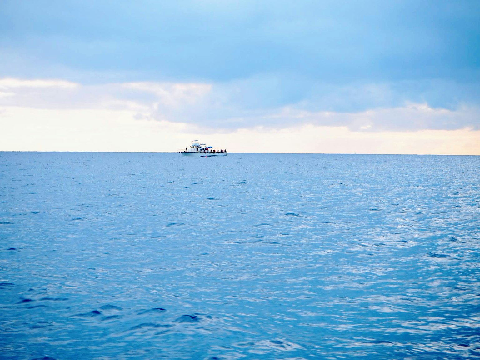 Paesaggio marino tranquillo con una vasta superficie d'acqua blu e cielo nuvoloso