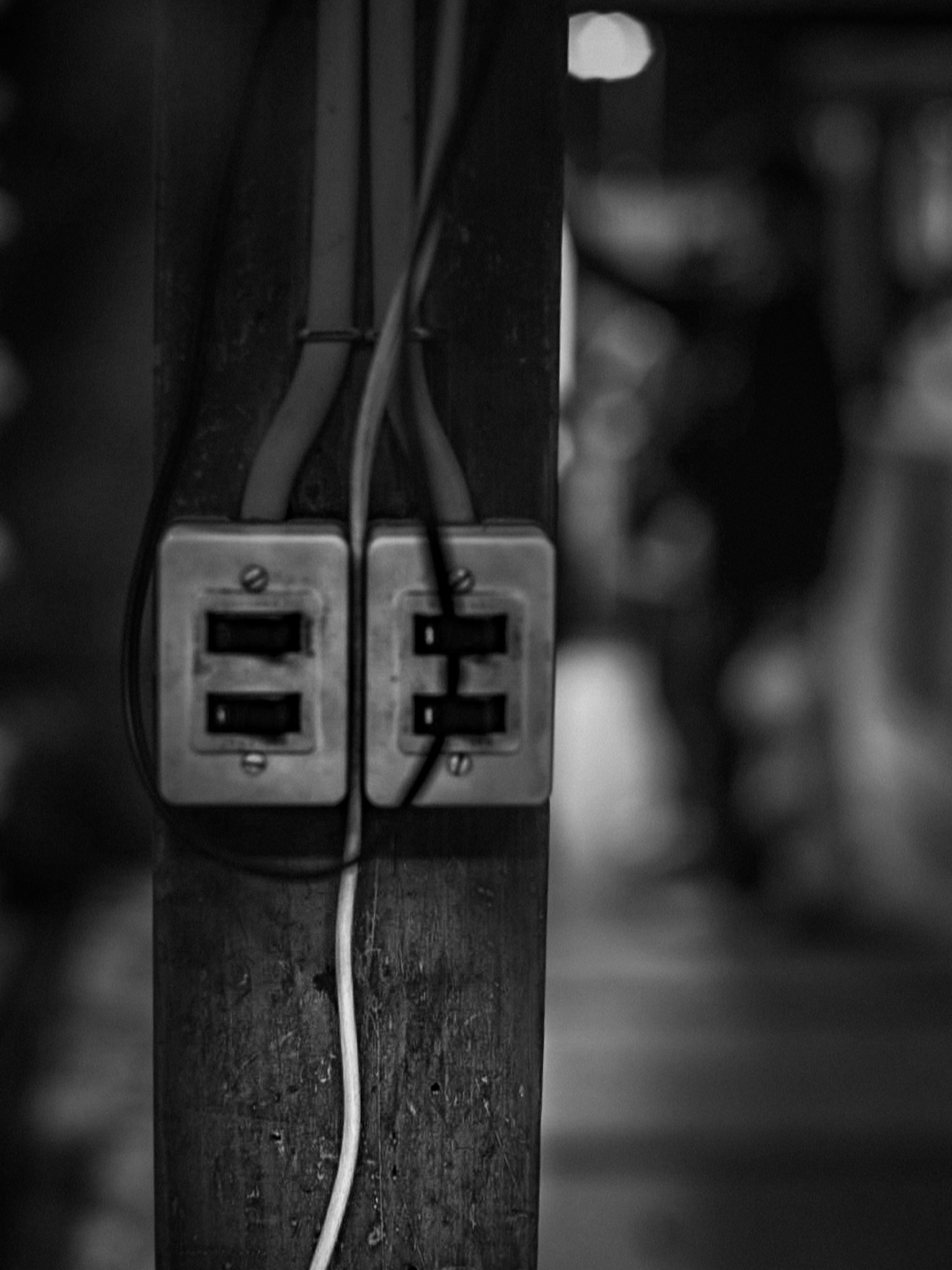 Vieja toma de corriente con cables sobre un fondo en blanco y negro
