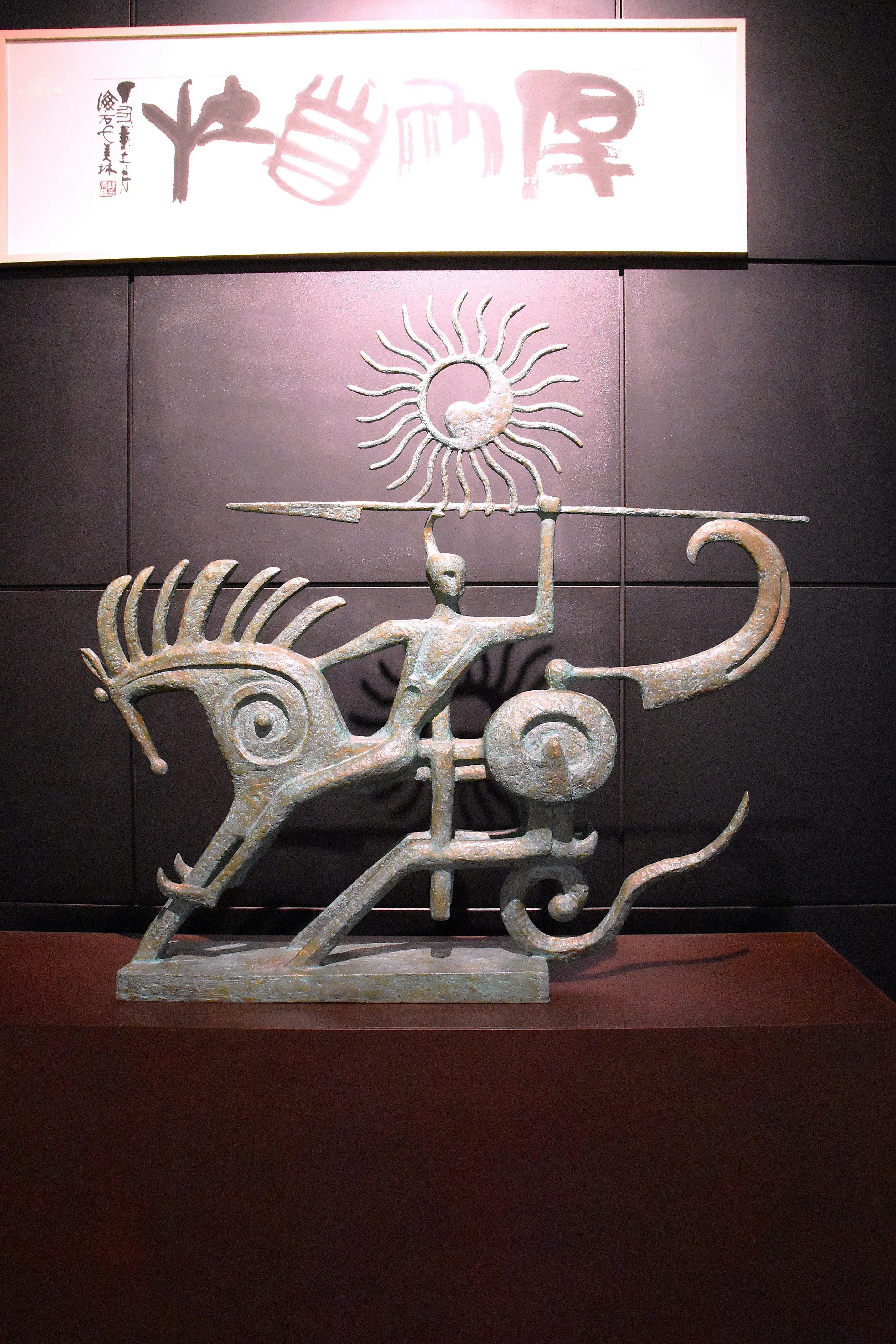 abstract metal sculpture displayed on a wall with an art sign