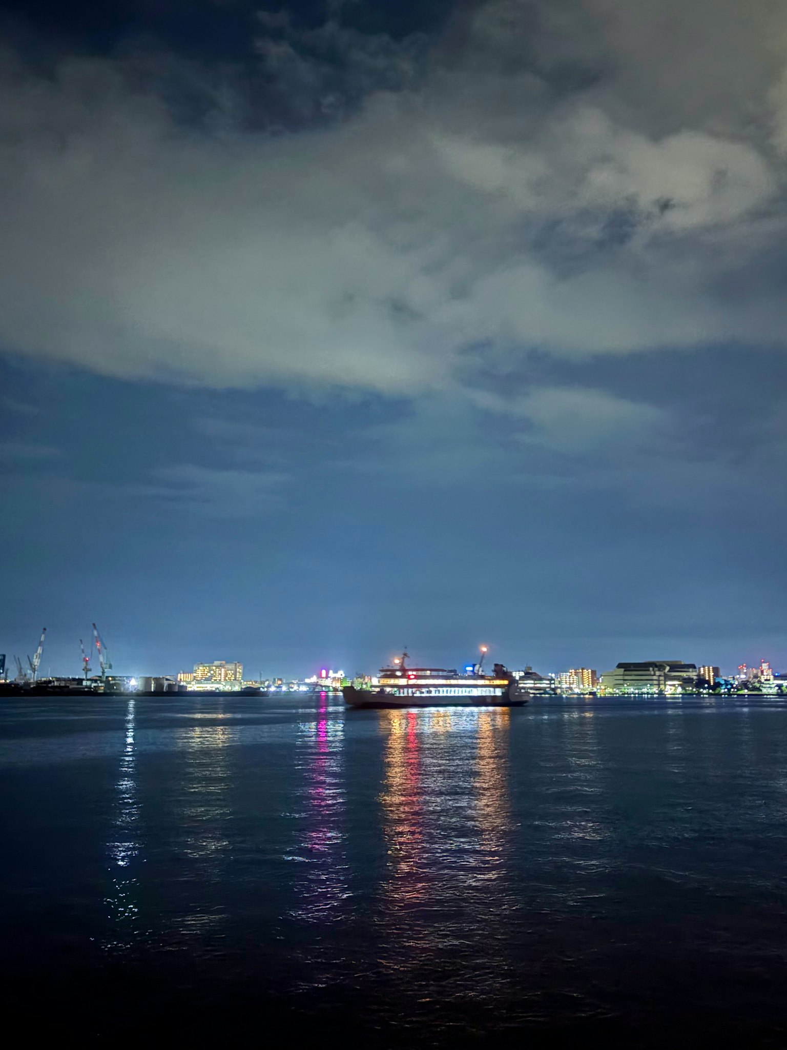 夜の海に浮かぶ船と反射する光