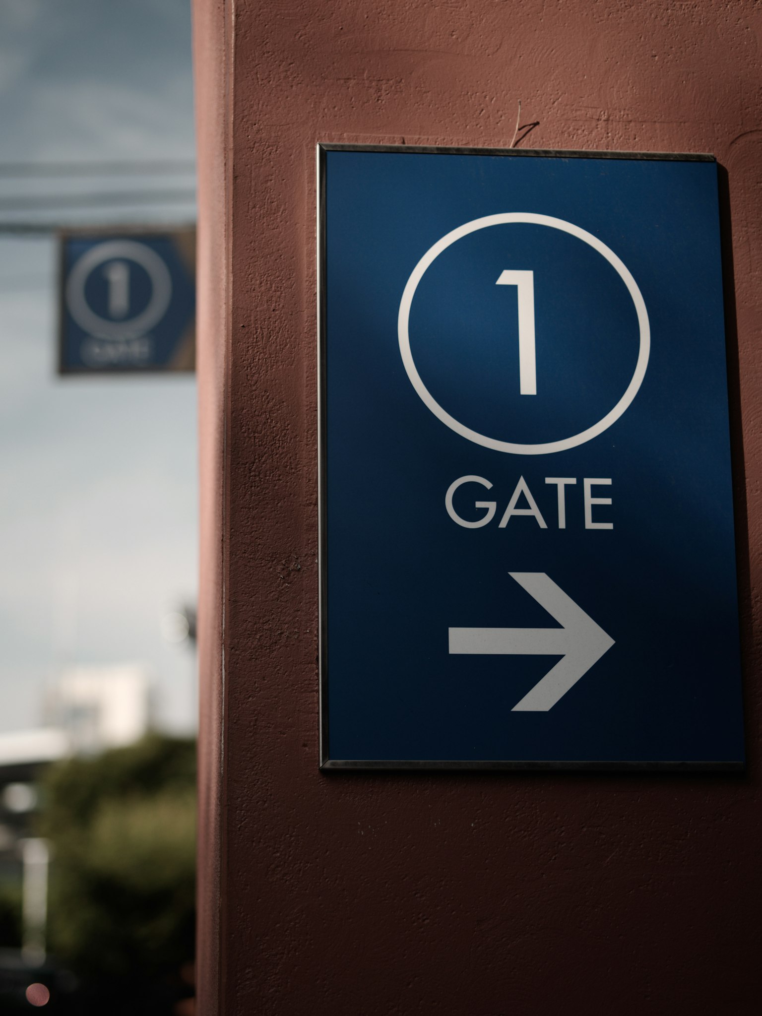 Panneau bleu indiquant la porte 1 avec une flèche pointant à droite