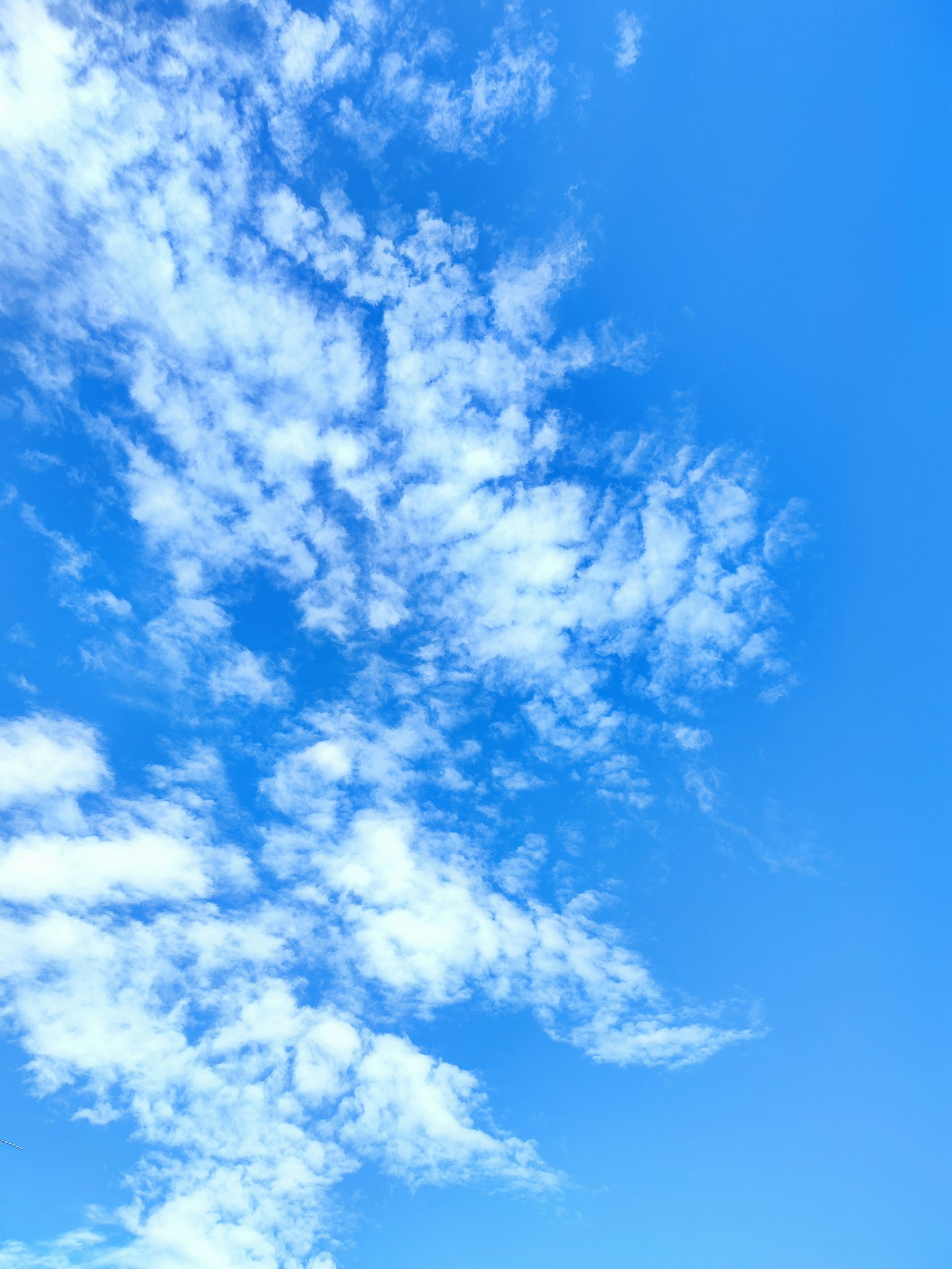 Ein klarer blauer Himmel mit flauschigen weißen Wolken