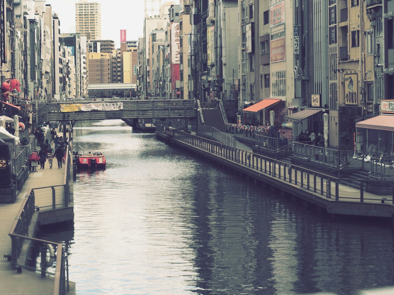 城市景观，运河旁有建筑和一只红色小船