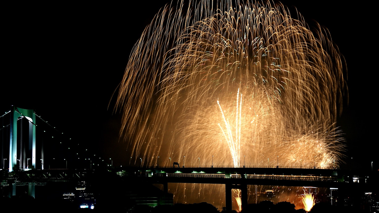 Beautiful fireworks display over the Rainbow Bridge at night