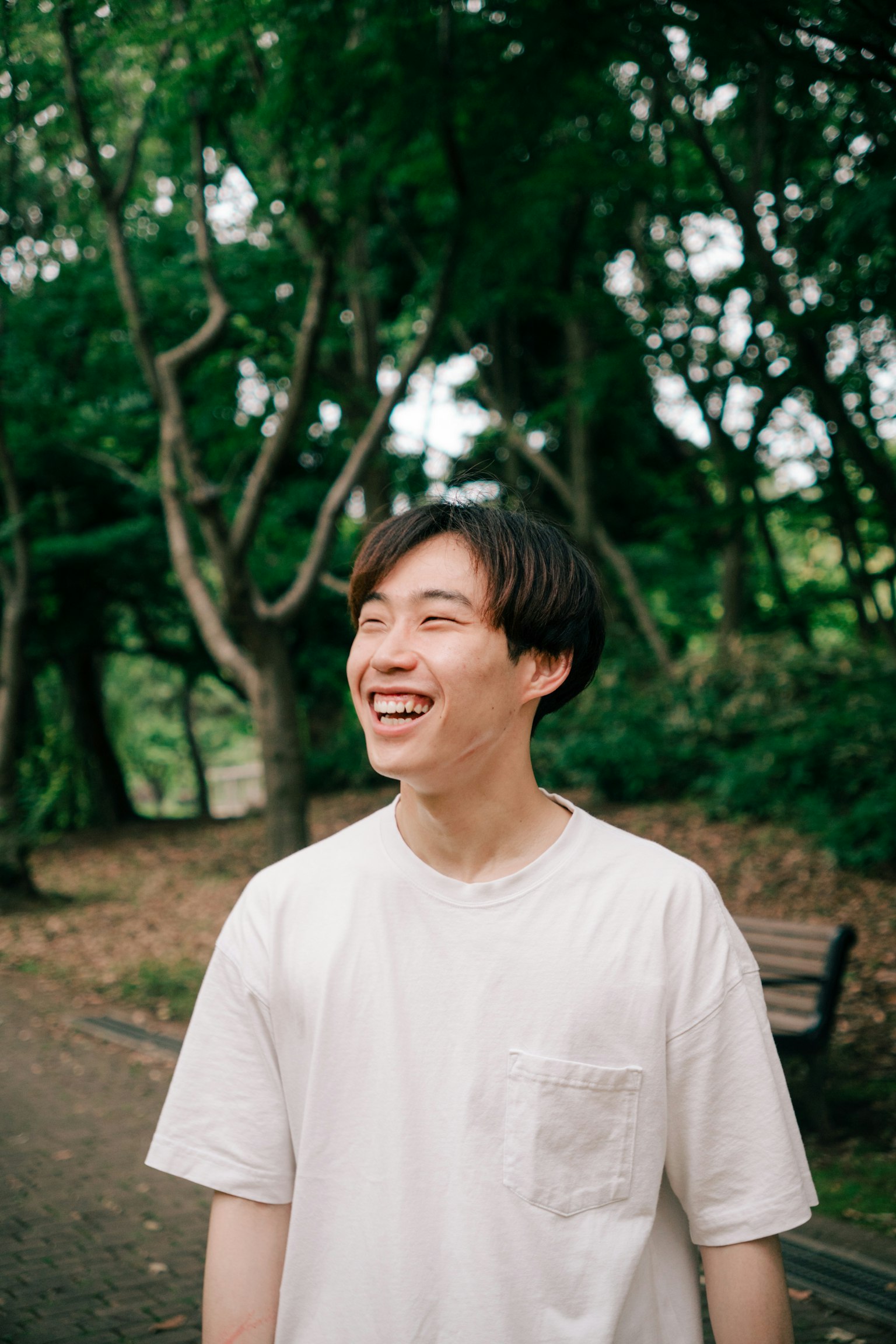 年轻男子在公园里微笑，背景为绿色