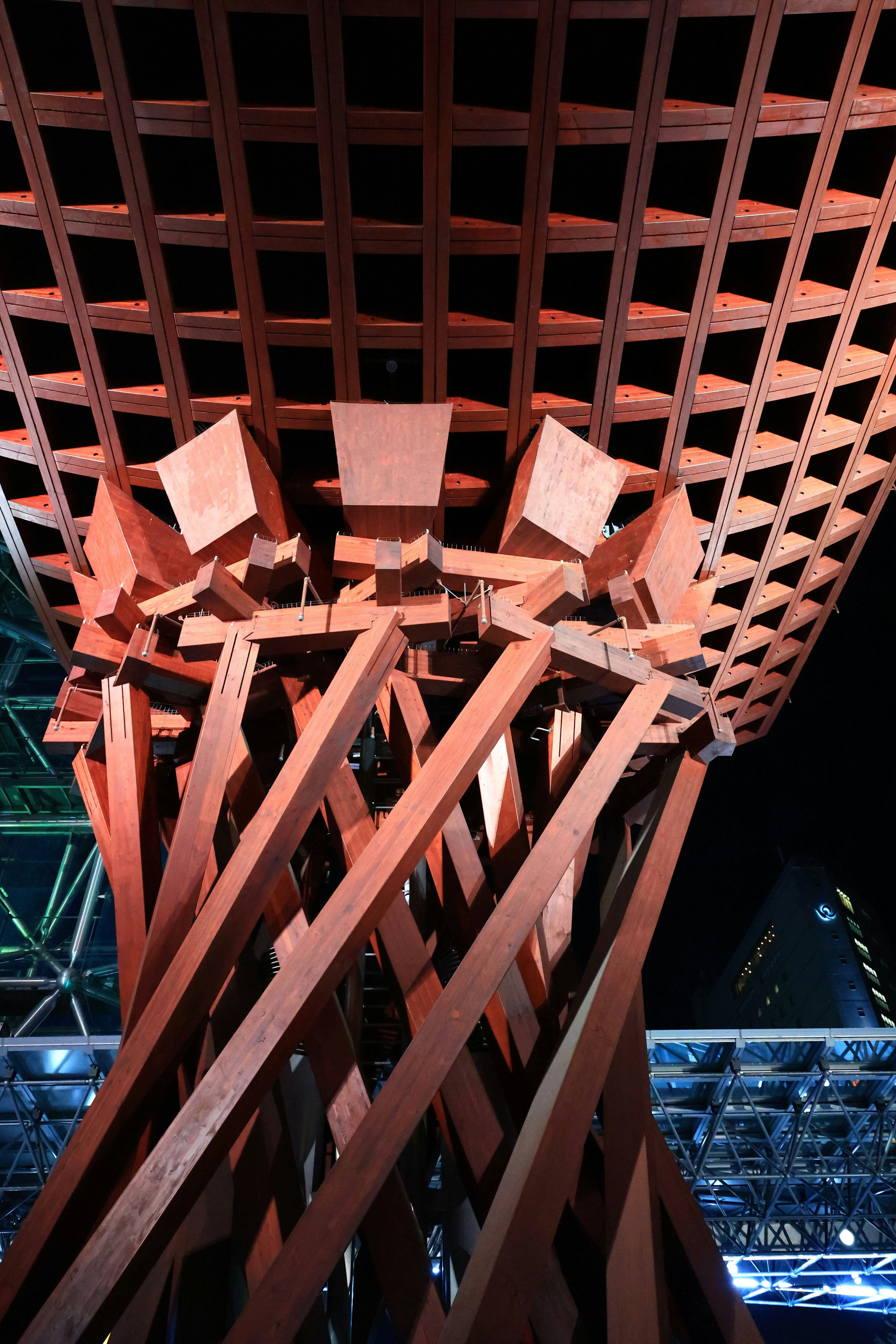 格子状の赤い建築梁と夜の屋内空間