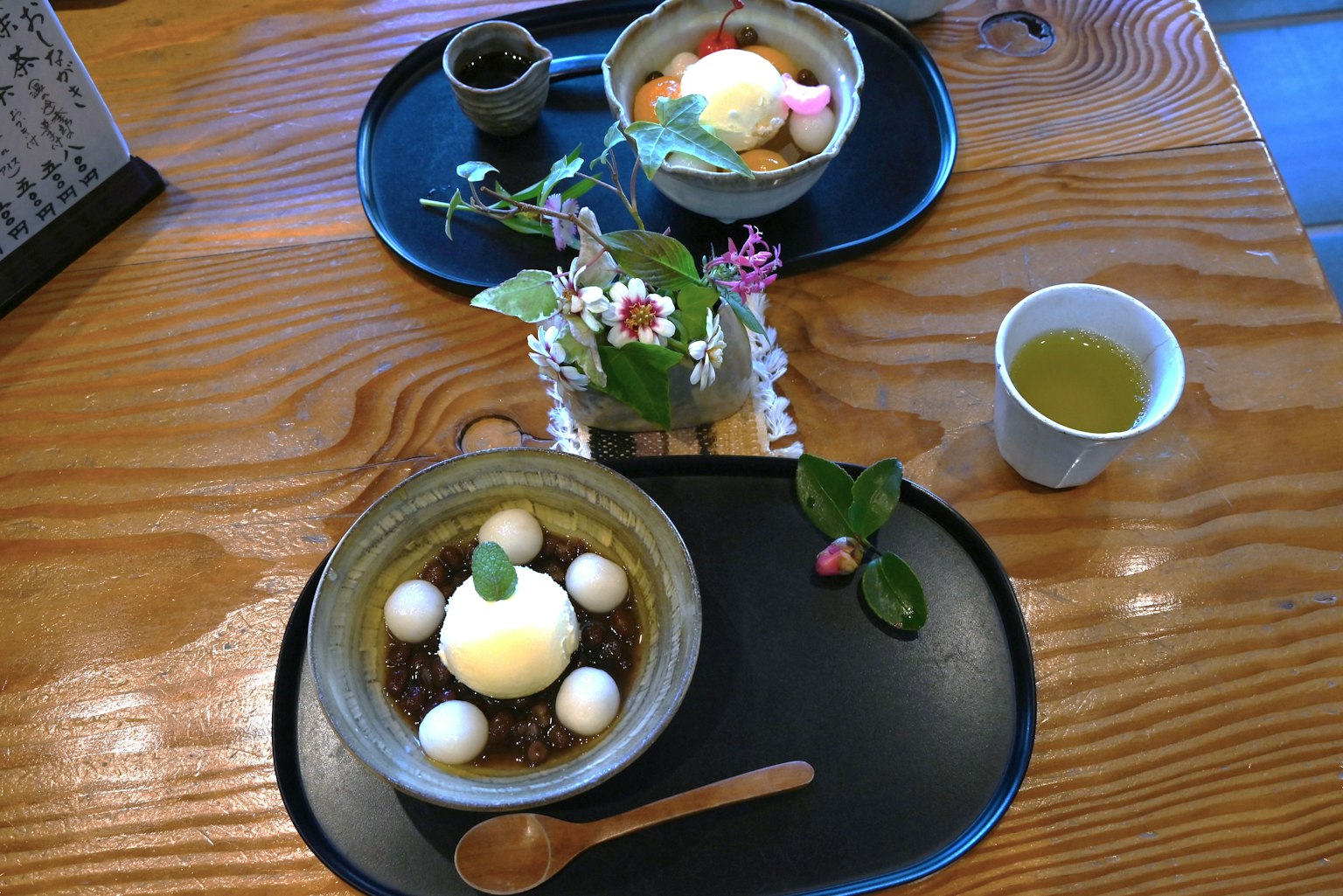 목재 표면에 아름답게 배치된 전통 일본 디저트와 녹차가 있는 테이블