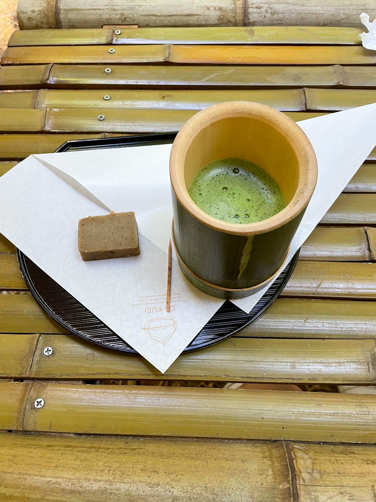 竹制杯中的抹茶饮料与竹桌上的甜点