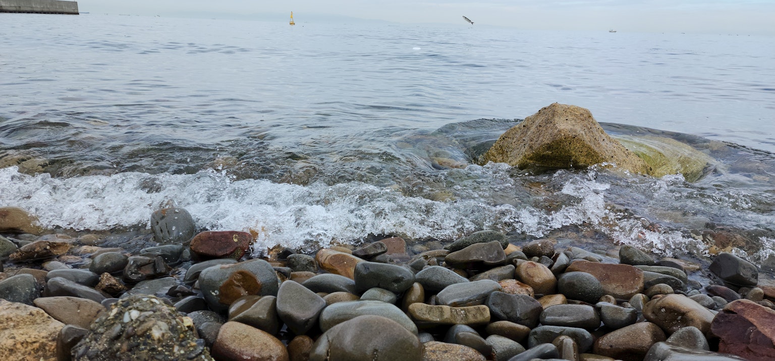 Piedras y olas en la orilla del agua