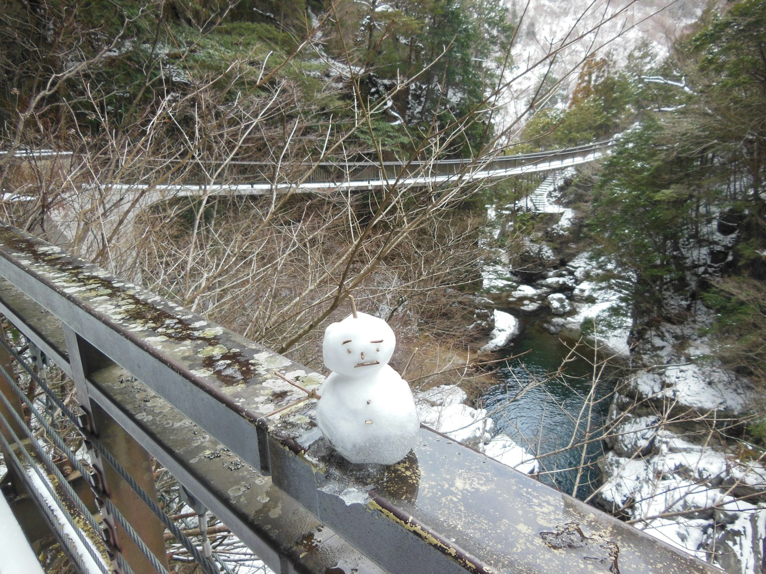 冬季景观中放置在桥栏杆上的雪人
