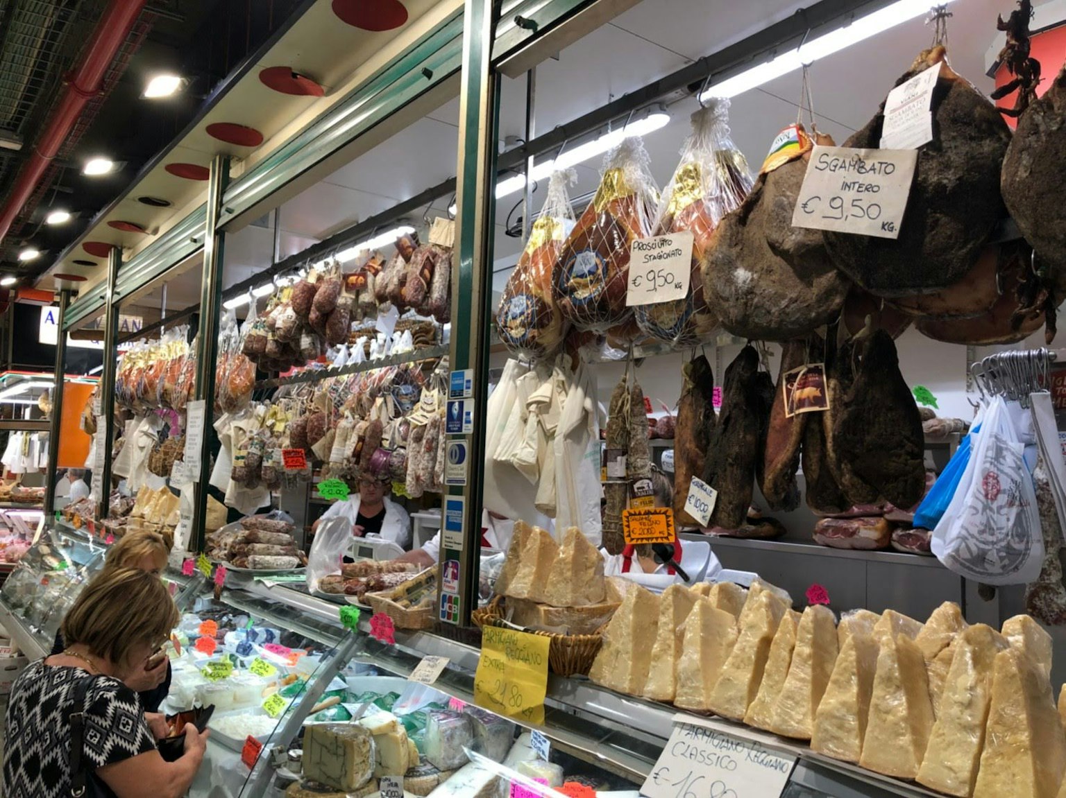 Exhibición de carnes y jamones colgados en un mercado